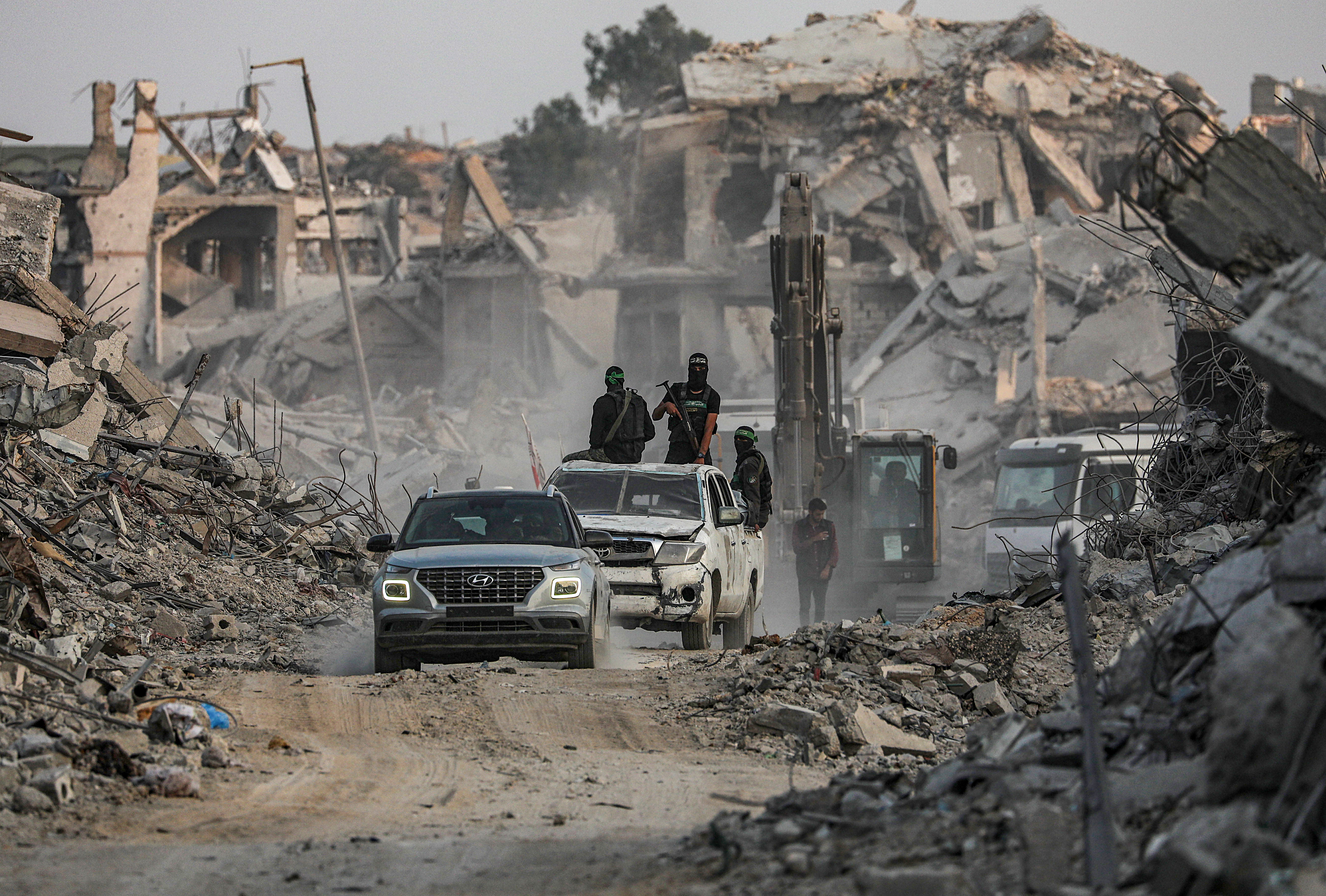 Fighters of the Al-Qassam Brigades, the military wing of the Hamas movement, searching for the bodies of Israeli hostages alongside Red Cross workers in Al Shejaeiya neighbourhood in the east of the Gaza City