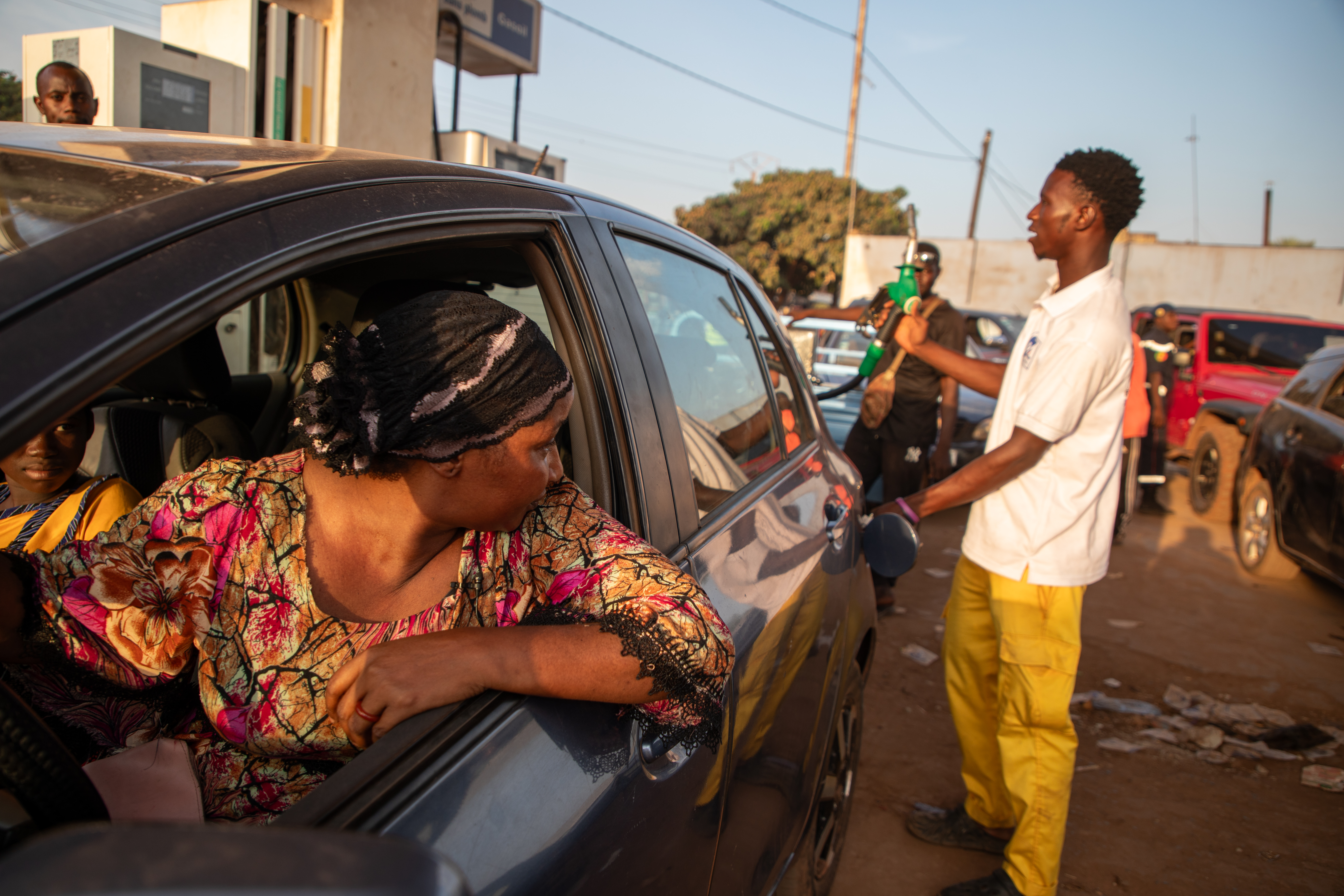 A woman waits to fill her car with fuel at a fuel station.