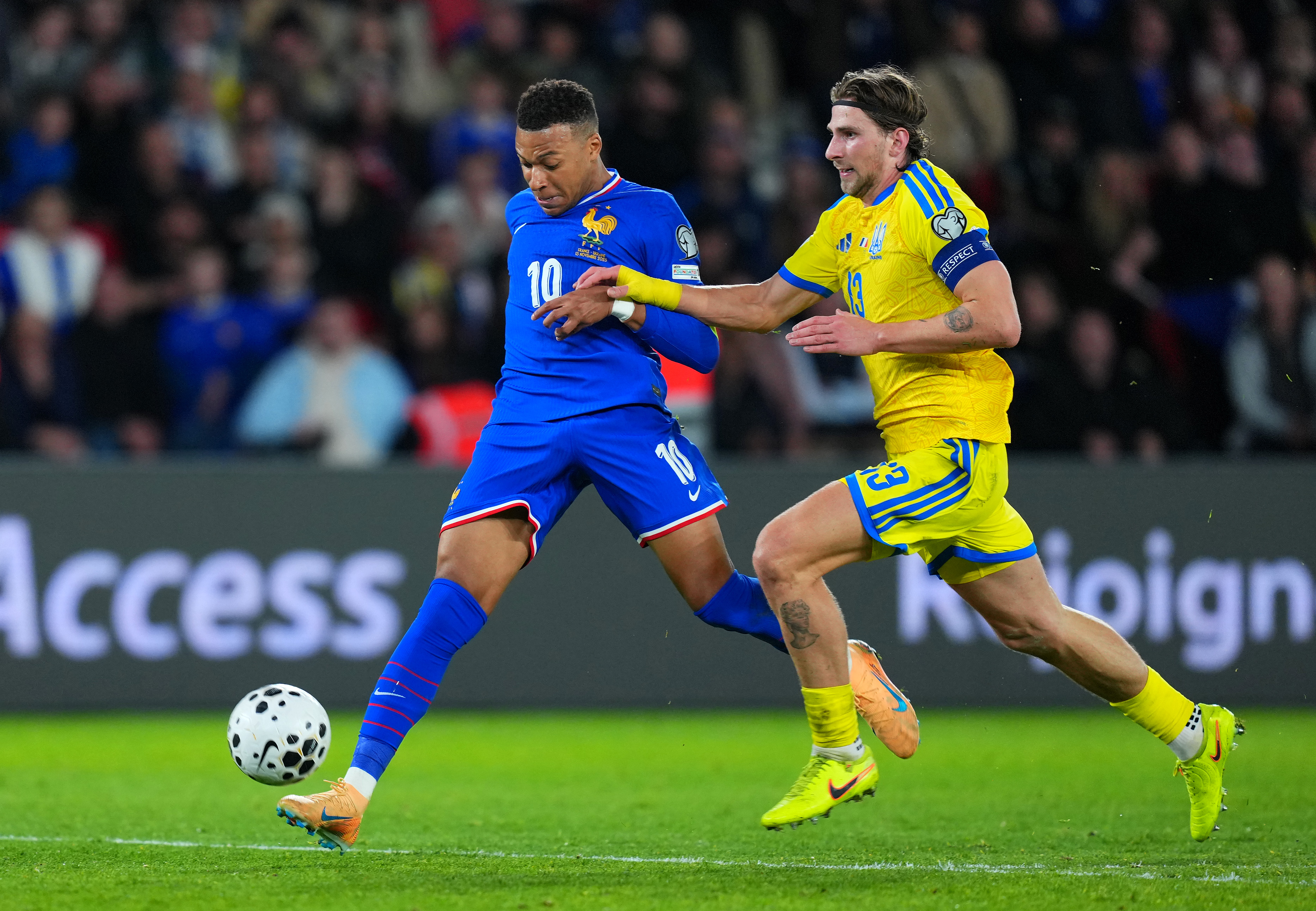 PARIS, FRANCE - NOVEMBER 13: Kylian Mbappe of France crosses the ball whilst under pressure from Illia Zabarnyi of Ukraine during the FIFA World Cup 2026 qualifier match between France and Ukraine at Parc des Princes on November 13, 2025 in Paris, France. (Photo by Franco Arland/Getty Images)