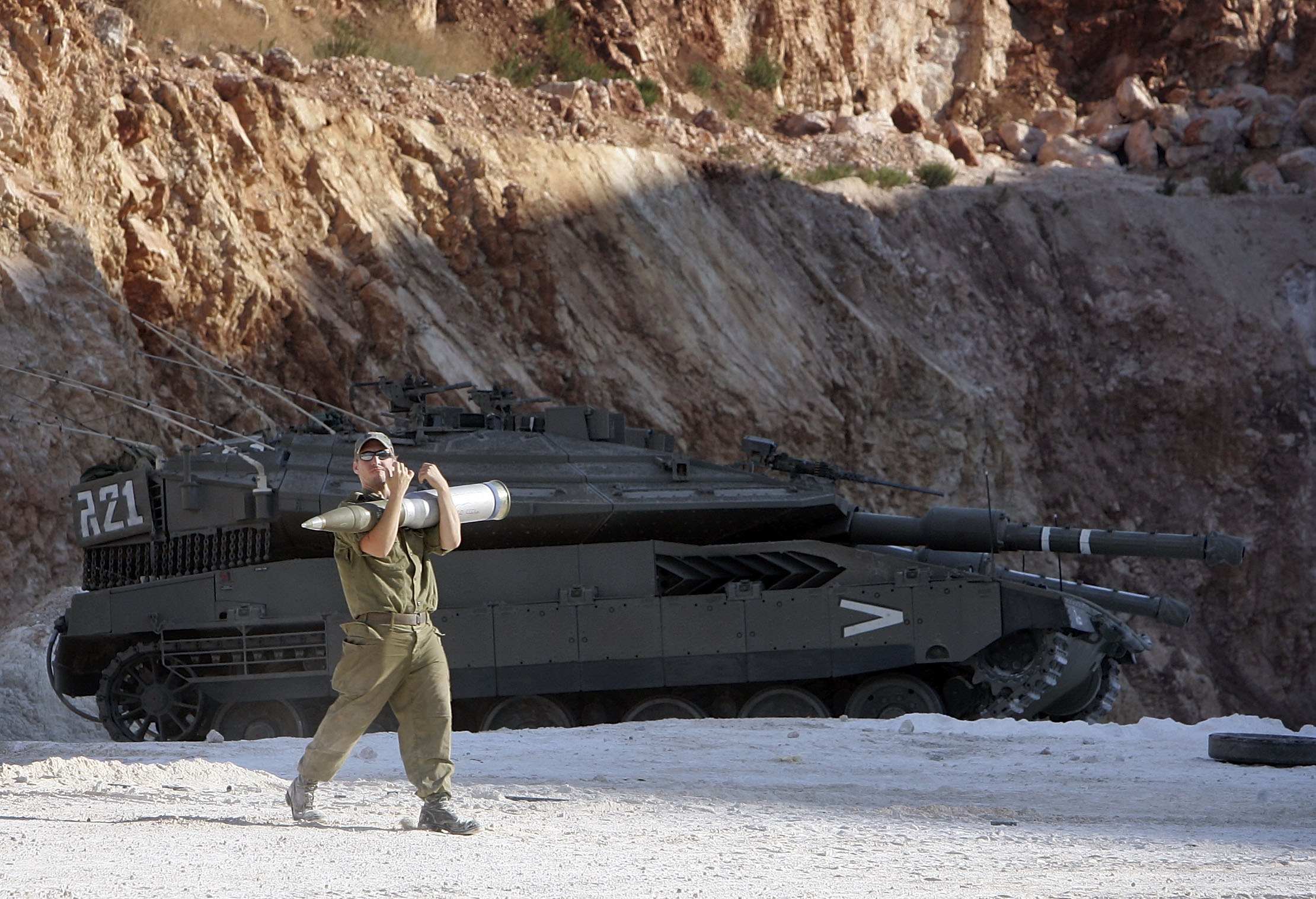 KIRYAT SHEMONA, ISRAEL - JULY 28: An Israeli Merkava tank crewman loads his vehicle with ammunition in a holding area near to the Israeli-Lebanon border on July 28, 2006, at a forward base near the northerly town of Kiryat Shemona, Israel. Fighting continues on the Israel-Lebanon border as British Prime Minister Tony Blair is en-route to Washington for talks with US President George W Bush on the Middle East crisis amid pressure for an immediate ceasefire between Israel and Hezbollah. (Photo by Christopher Furlong/Getty Images)