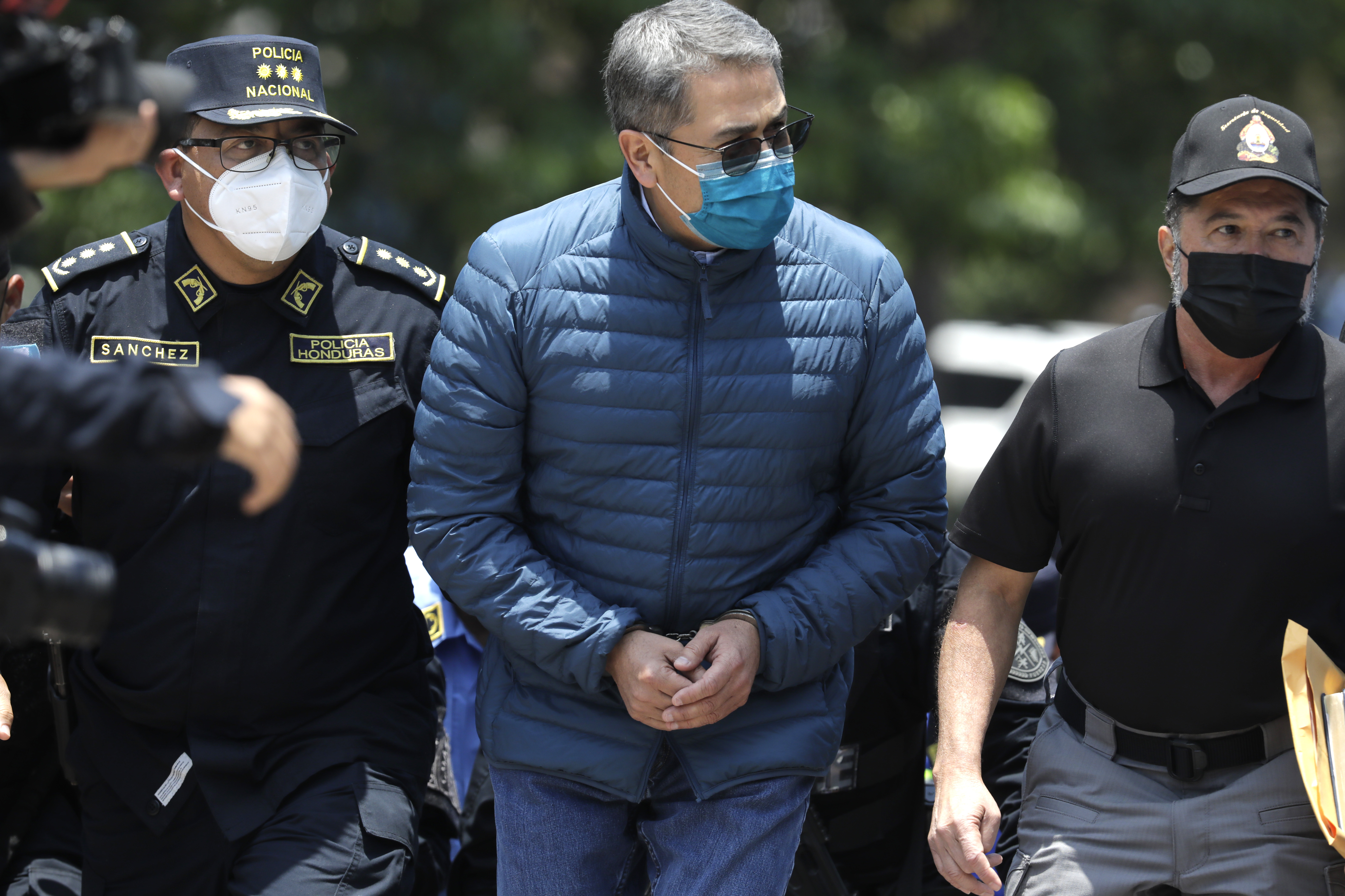 TEGUCIGALPA, HONDURAS - APRIL 21: Former President of Honduras Juan Orlando Hernandez is escorted by Members of the Police Special Forces to be extradited to U.S.to face charges of taking bribes from drug traffickers at Honduran National Directorate of Special Forces on April 21, 2022 in Tegucigalpa, Honduras. Hernandez will stand trial for allegedly aiding the smuggling of hundreds of tons of cocaine to America (Photo by Jorge Cabrera/Getty Images)