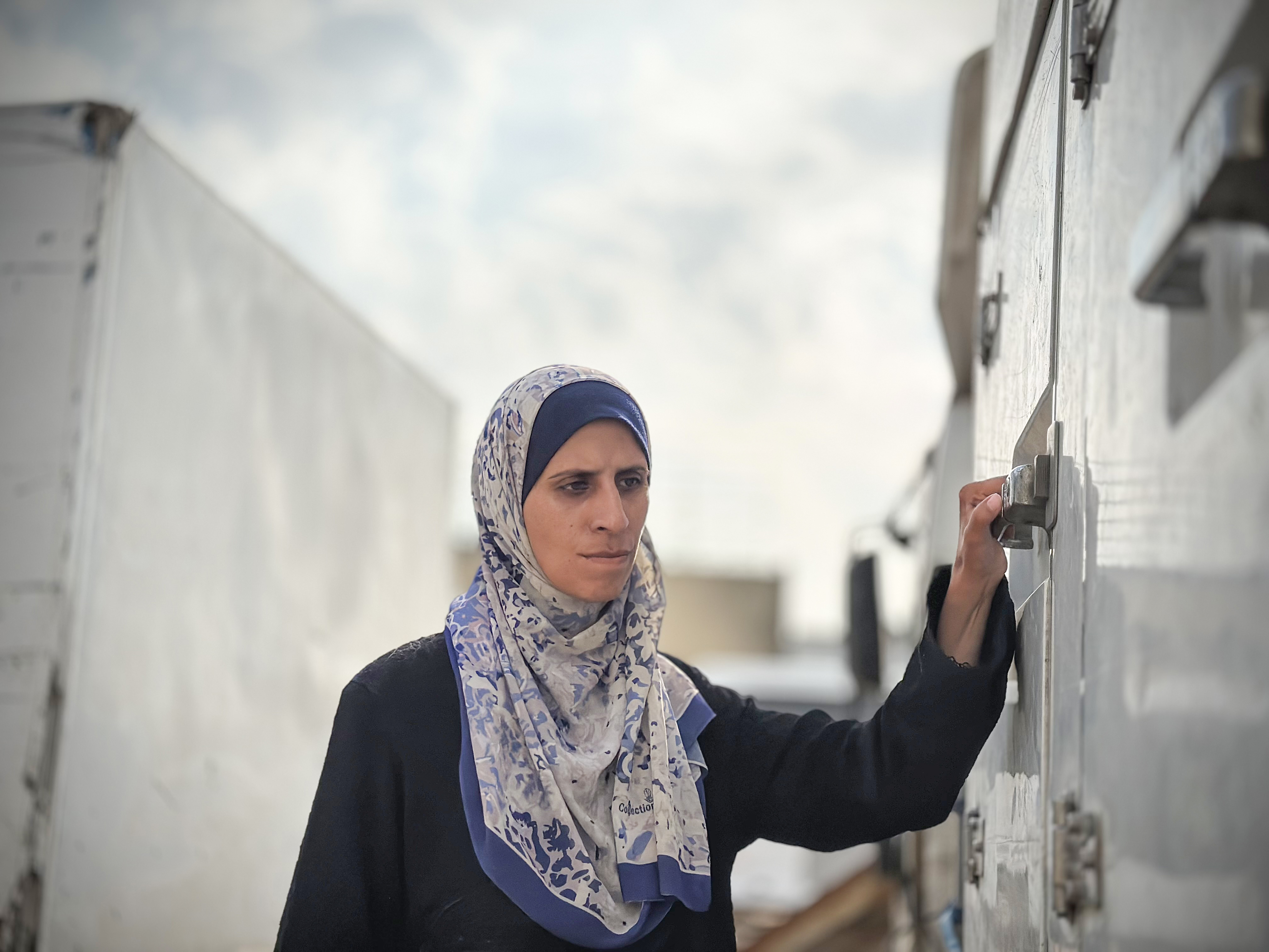 Israa al-Areer waits outside a mortuary fridge