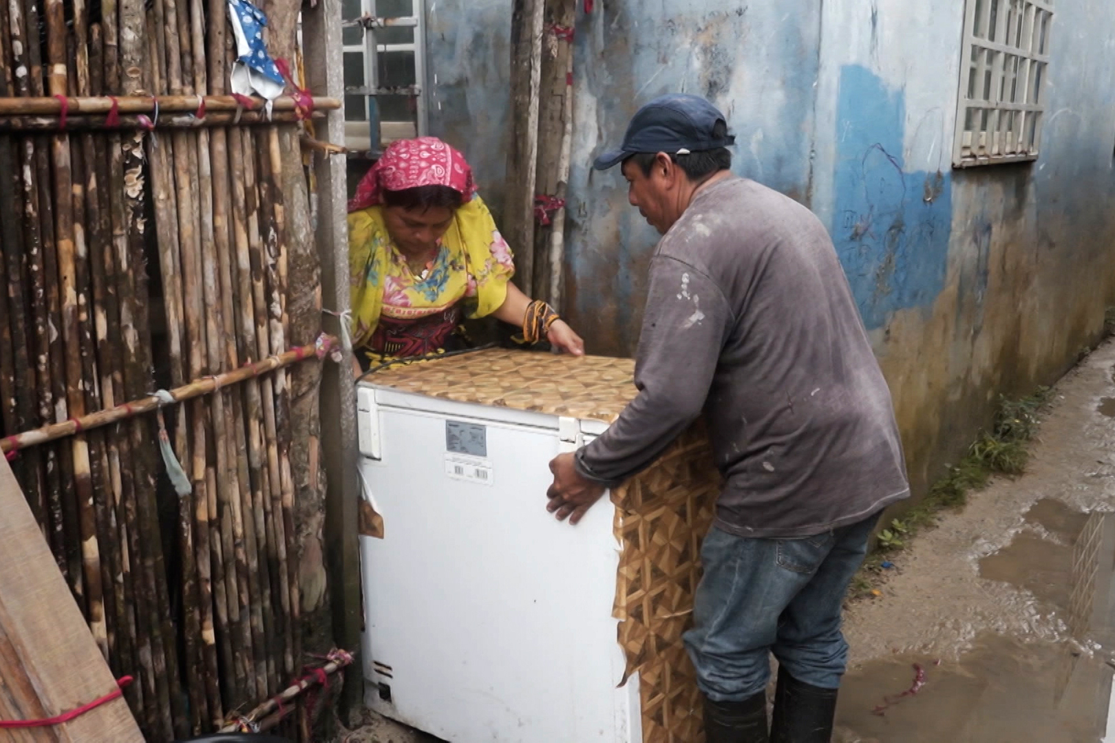Two members of Panama's indigenous Guna community move an appliance as they relocate from the island of Gardi Sugdub to the newly built Isberyala on the mainland. [Al Jazeera]