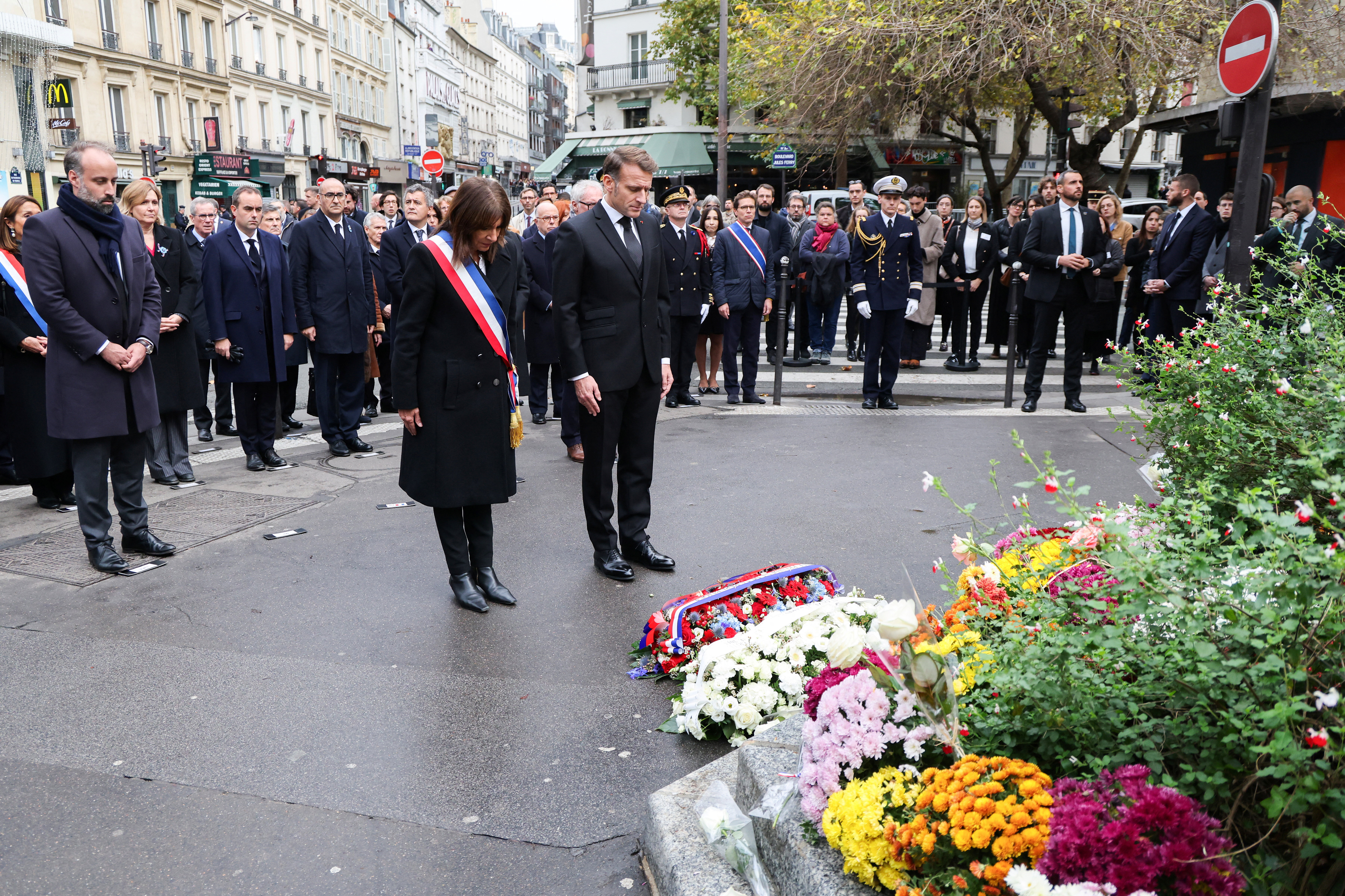 President of the Life for Paris victims association Arthur Denouveaux, Paris' mayor Anne Hidalgo and France's President Emmanuel Macron pay tribute to victims at intersection of Faubourg du Temple and Boulevard Jules Ferry near “La Bonne Biere” cafe in Paris on November 13, 2025, during ceremonies across Paris marking a decade since the terror attacks of November 13, 2015 in which 130 civilians were killed. LUDOVIC MARIN/Pool via REUTERS