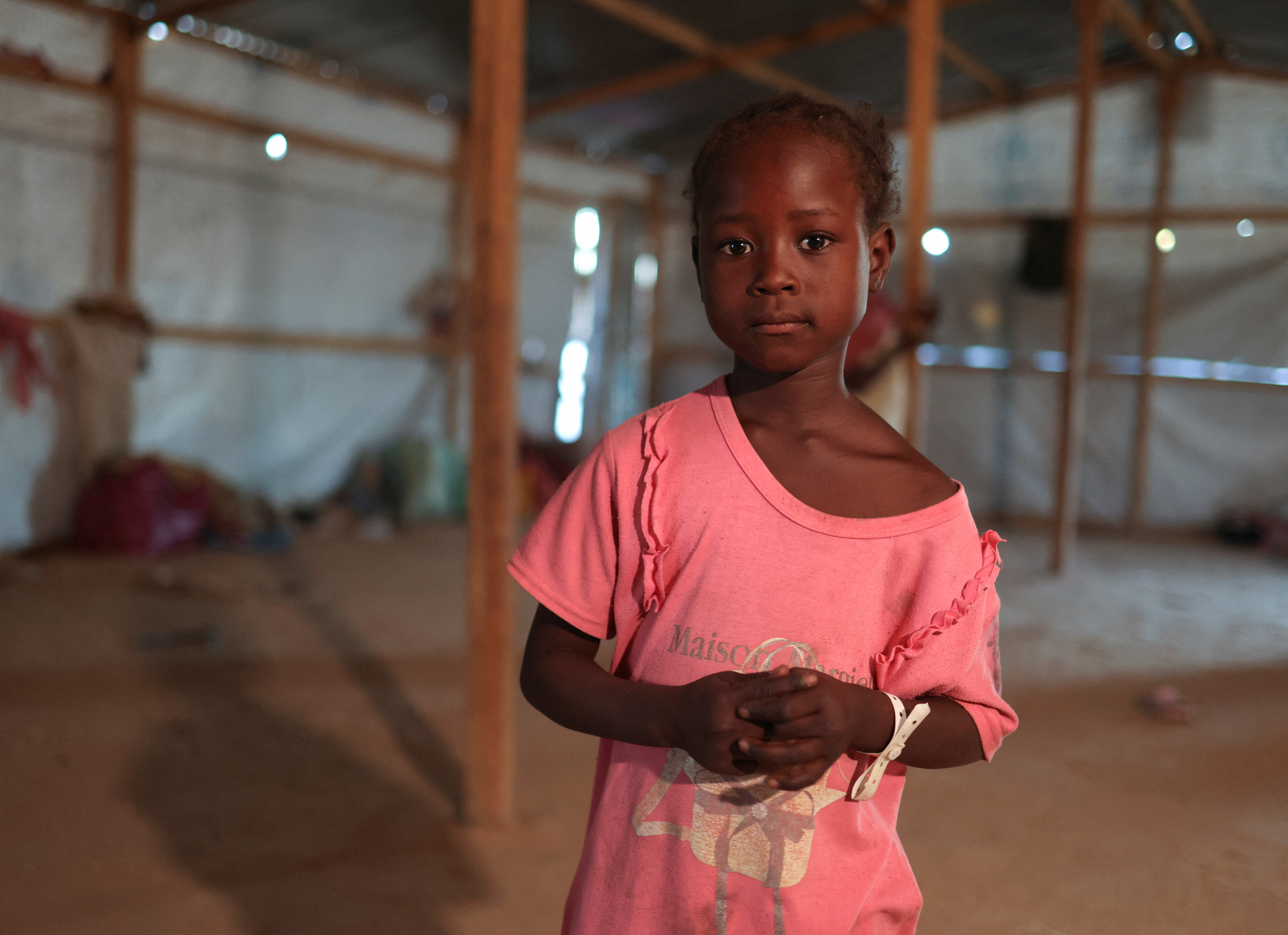 Mabroka Adam, 7 a Sudanese refugee girl from al-Fashir, poses inside her family tent at the Tine transit refugee camp in eastern Chad, November 22, 2025. Mabroka dreams of going to school and eating food, far from the conflict in Sudan, amid ongoing fighting between the paramilitary Rapid Support Forces (RSF) and the Sudanese army. REUTERS/Amr Abdallah Dalsh
