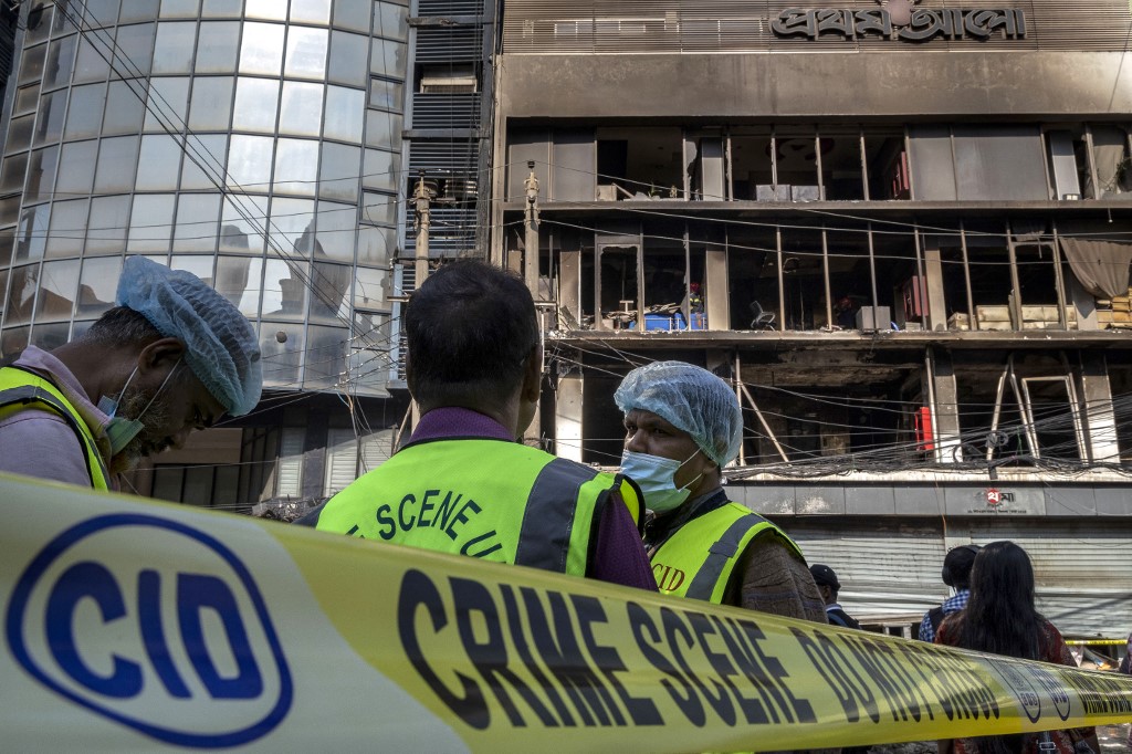 Bangladesh's Criminal Investigation Department (CID) personnel stand outside the burnt and vandalised building of the Prothom Alo newspaper in Dhaka on December 19, 2025. [Abdul Goni/ AFP]