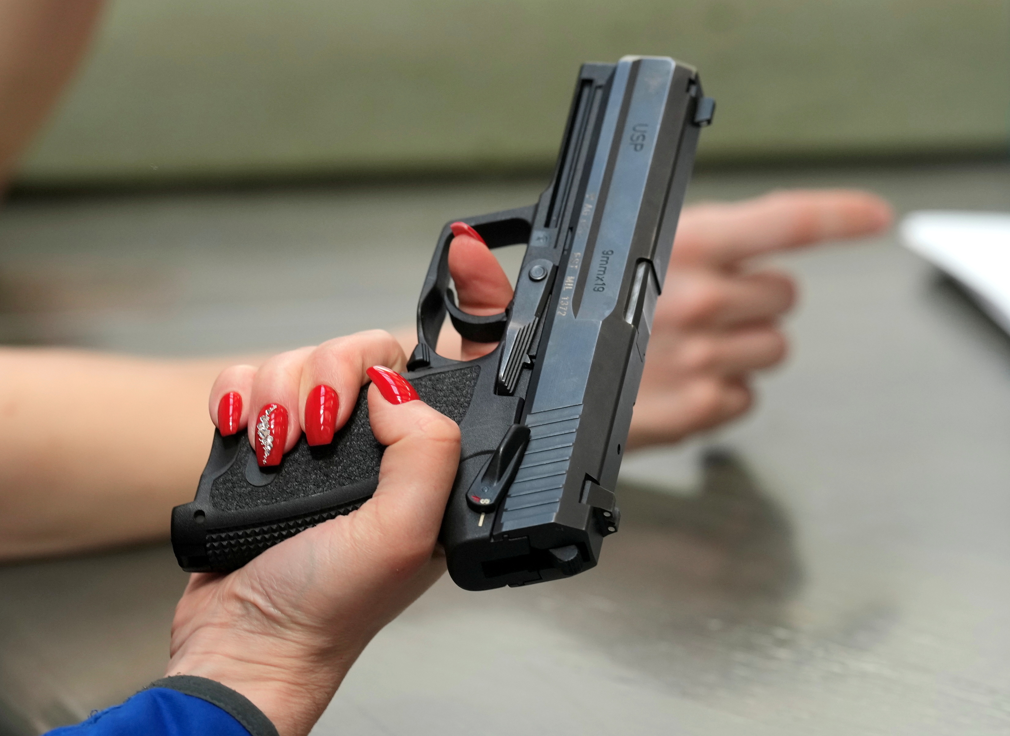 A member of Estonian women's voluntary defence organization holds a pistol gun during her training in Padise, Estonia March 20, 2022. Picture taken March 20, 2022. [Ints Kalnins/Reuters]