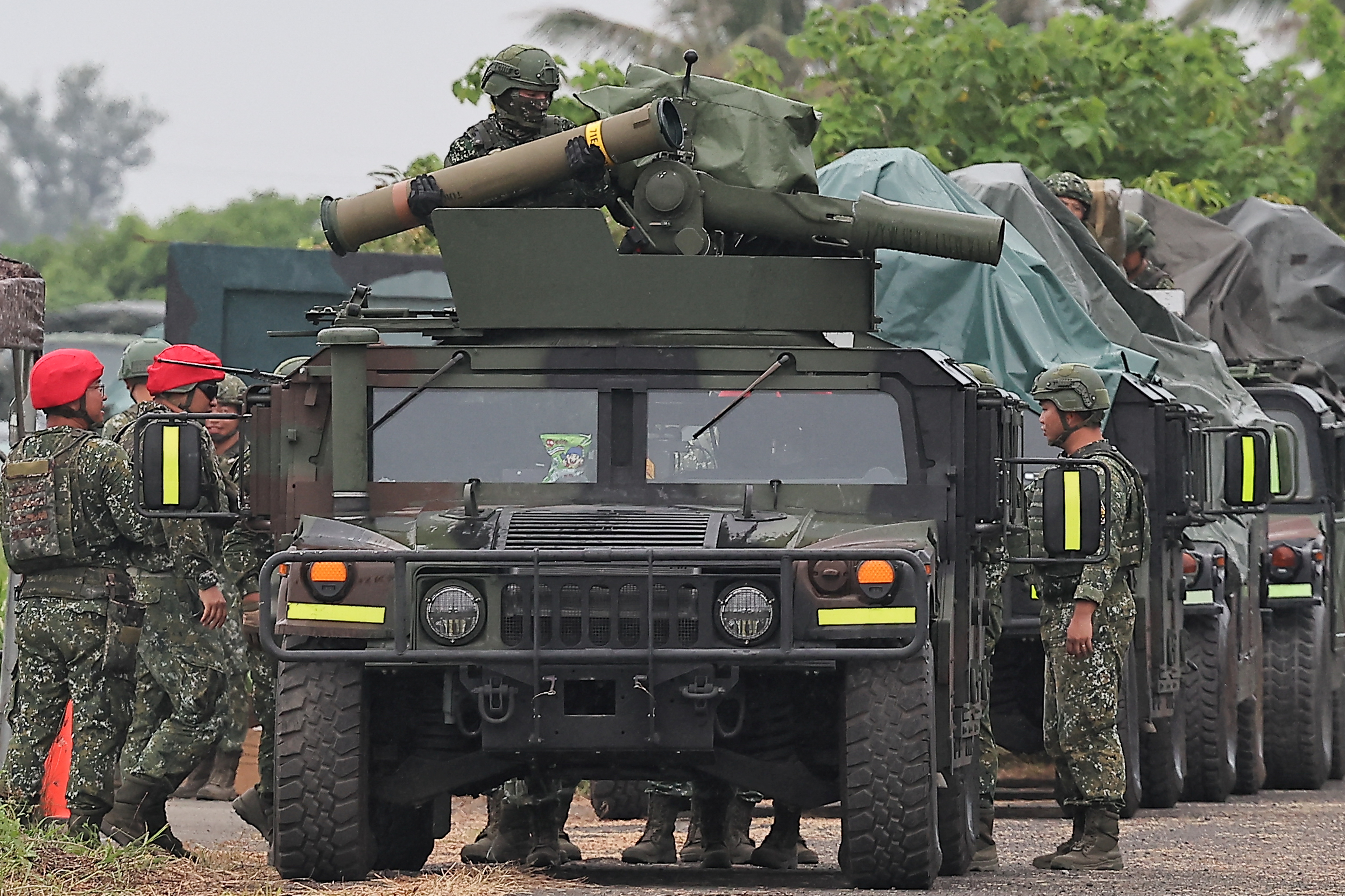 A soldier holds an antitank missile on a carrier vehicle.