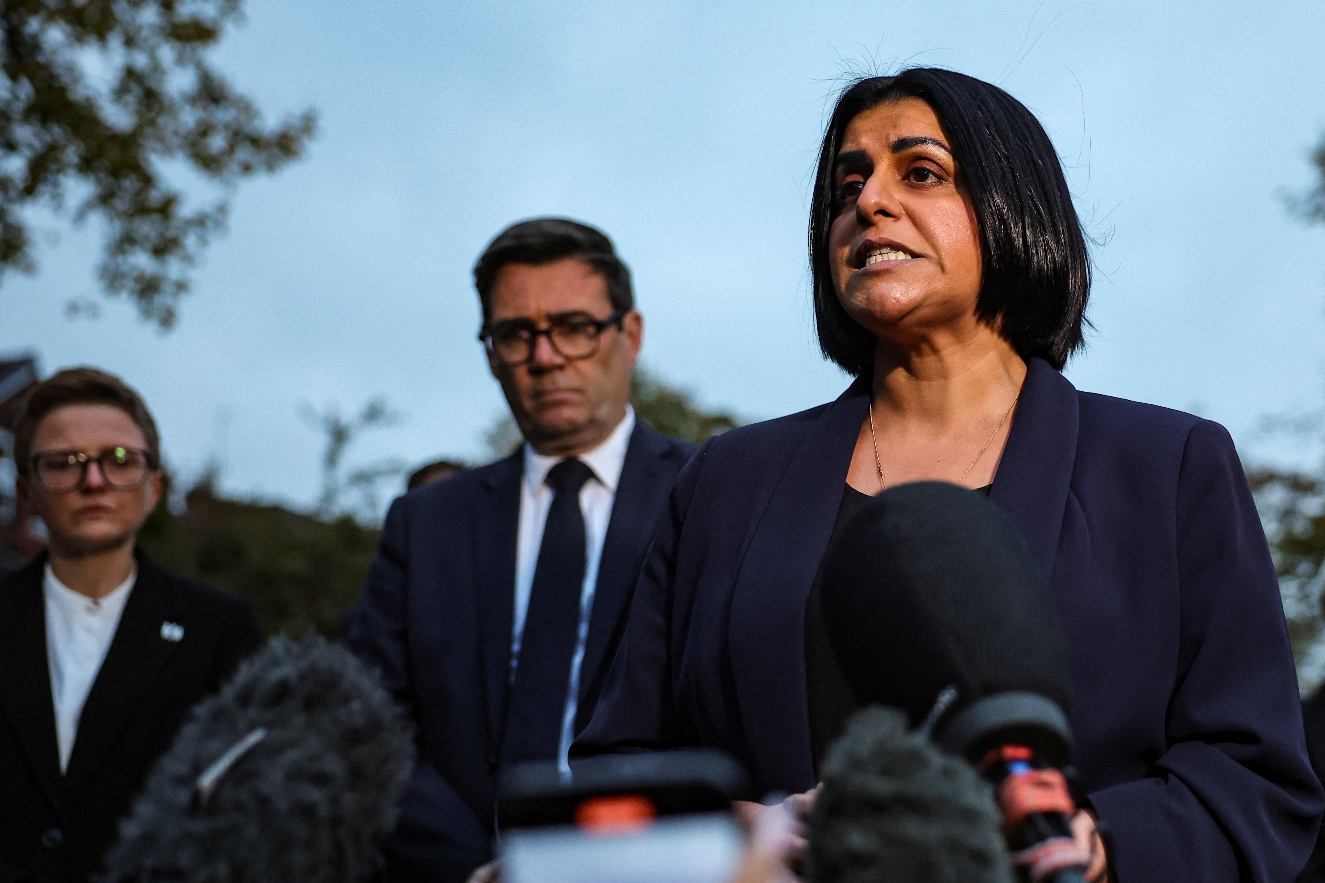 British Home Secretary Shabana Mahmood, next to Mayor of Greater Manchester Andy Burnham and Leader of Manchester City Council Cllr Bev Craig, makes a statement at Crumpsall Lane after a man drove a car into pedestrians and stabbed a security guard in an attack at a synagogue where worshippers were marking Yom Kippur, the holiest day on the Jewish calendar, according to the British police, in north Manchester, Britain, October 2, 2025. REUTERS/Phil Noble