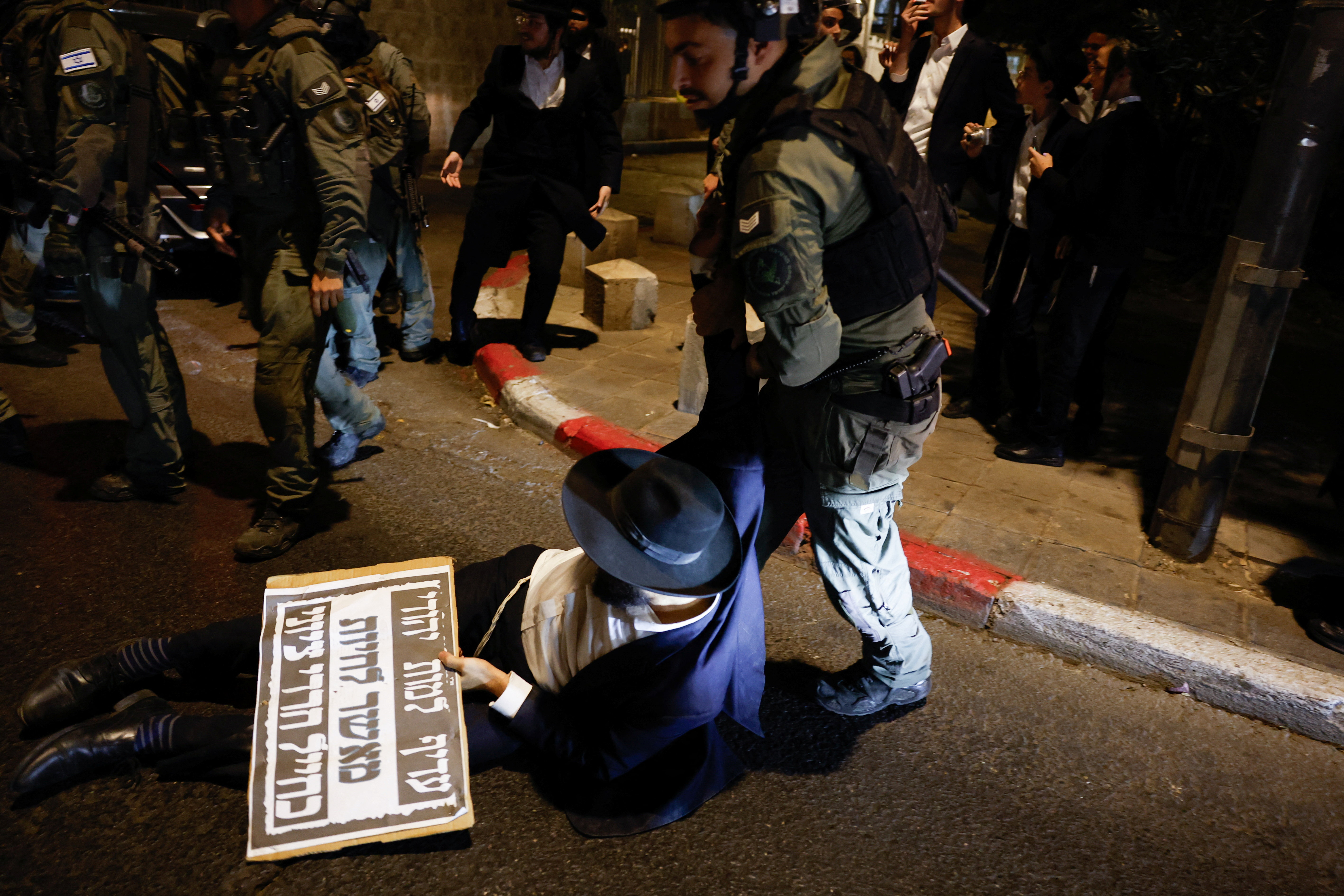 An Israeli police officer pulls an ultra-Orthodox Jew during a protest.