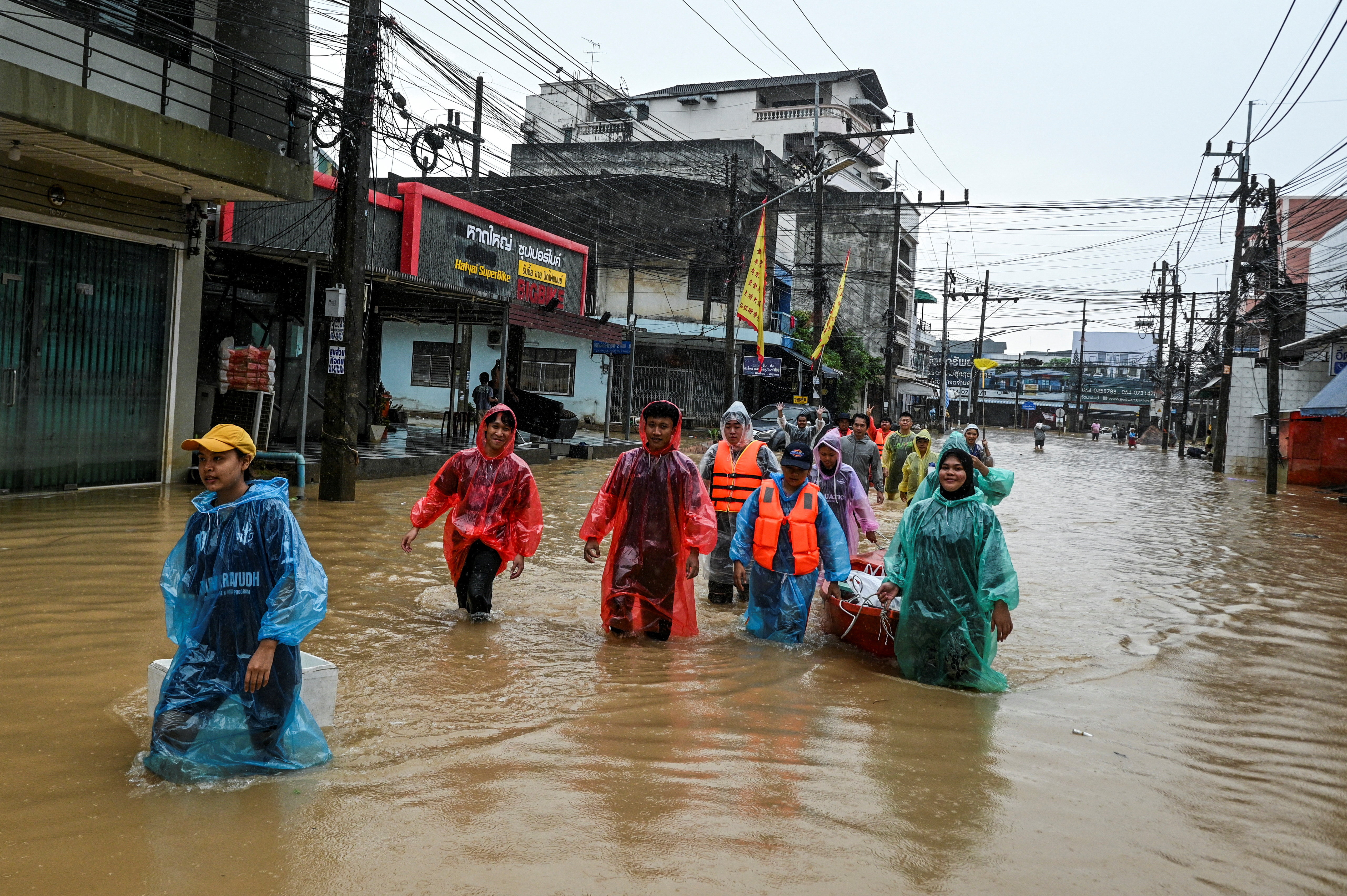 Volunteers wade through floodwater as they carry relief supplies to distribute to stranded local residents, on a flooded street in Hat Yai district, affected by deadly heavy rainfall, which has impacted several provinces in southern Thailand, in Songkhla province, Thailand, November 26, 2025. REUTERS/Karit Chaui-aksorn