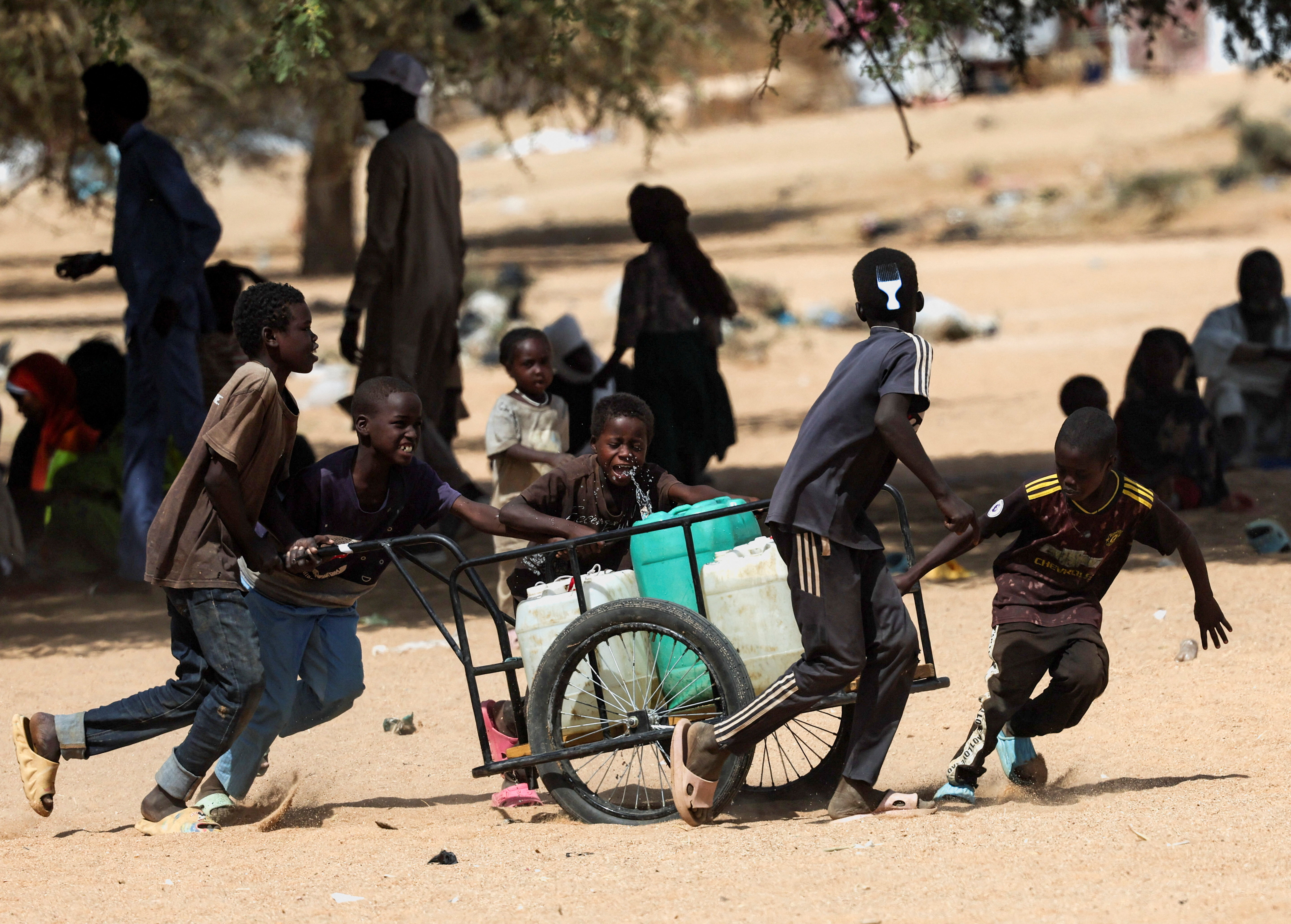 Sudanese refugee boys from Darfur carry canisters at the Iridimi refugee camp in Wadi Fira province, Chad