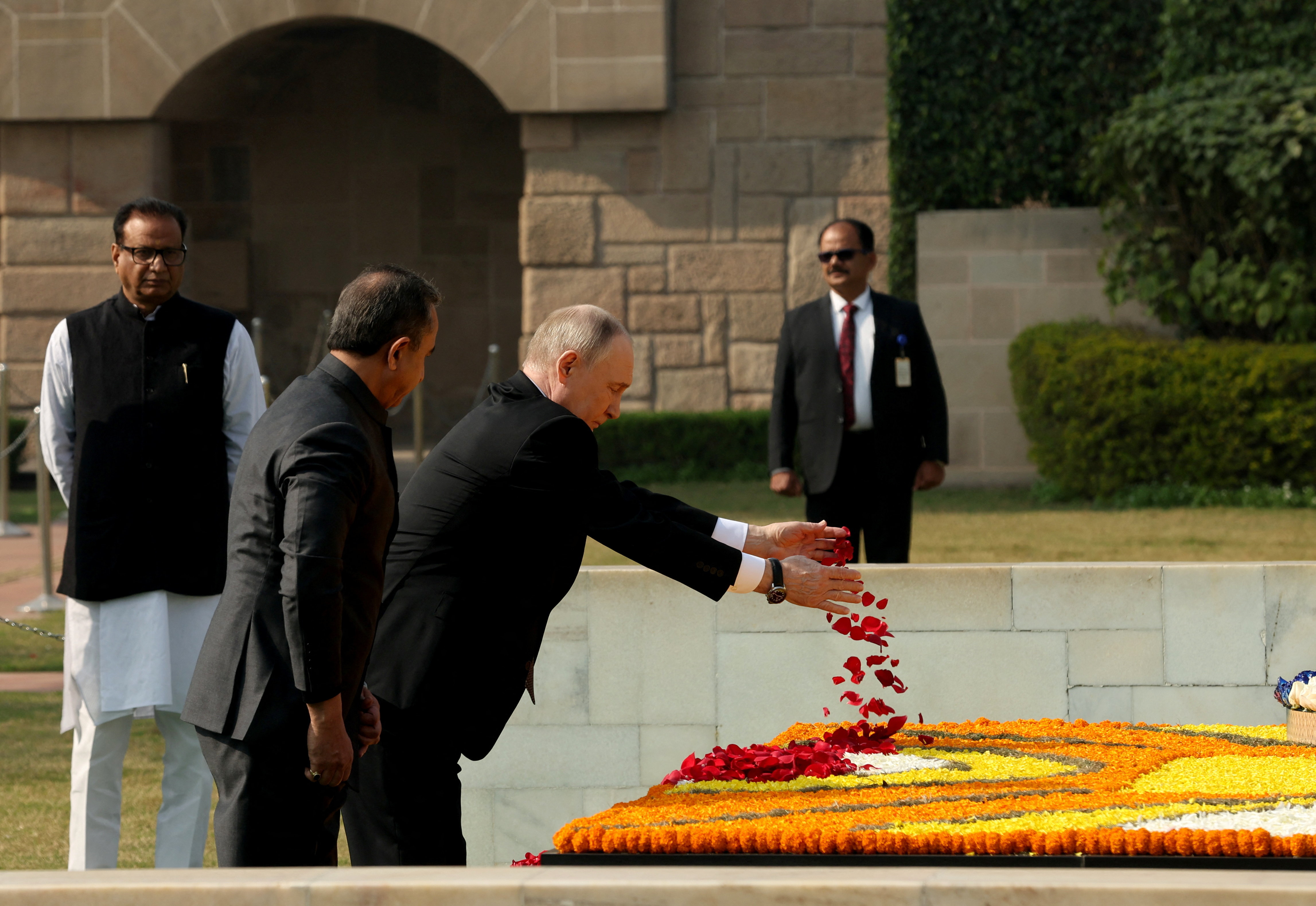 Russian President Vladimir Putin scatters rose petals as he pays homage at the Mahatma Gandhi memorial at Rajghat in New Delhi, India December 5, 2025. REUTERS/Pankaj Nangia