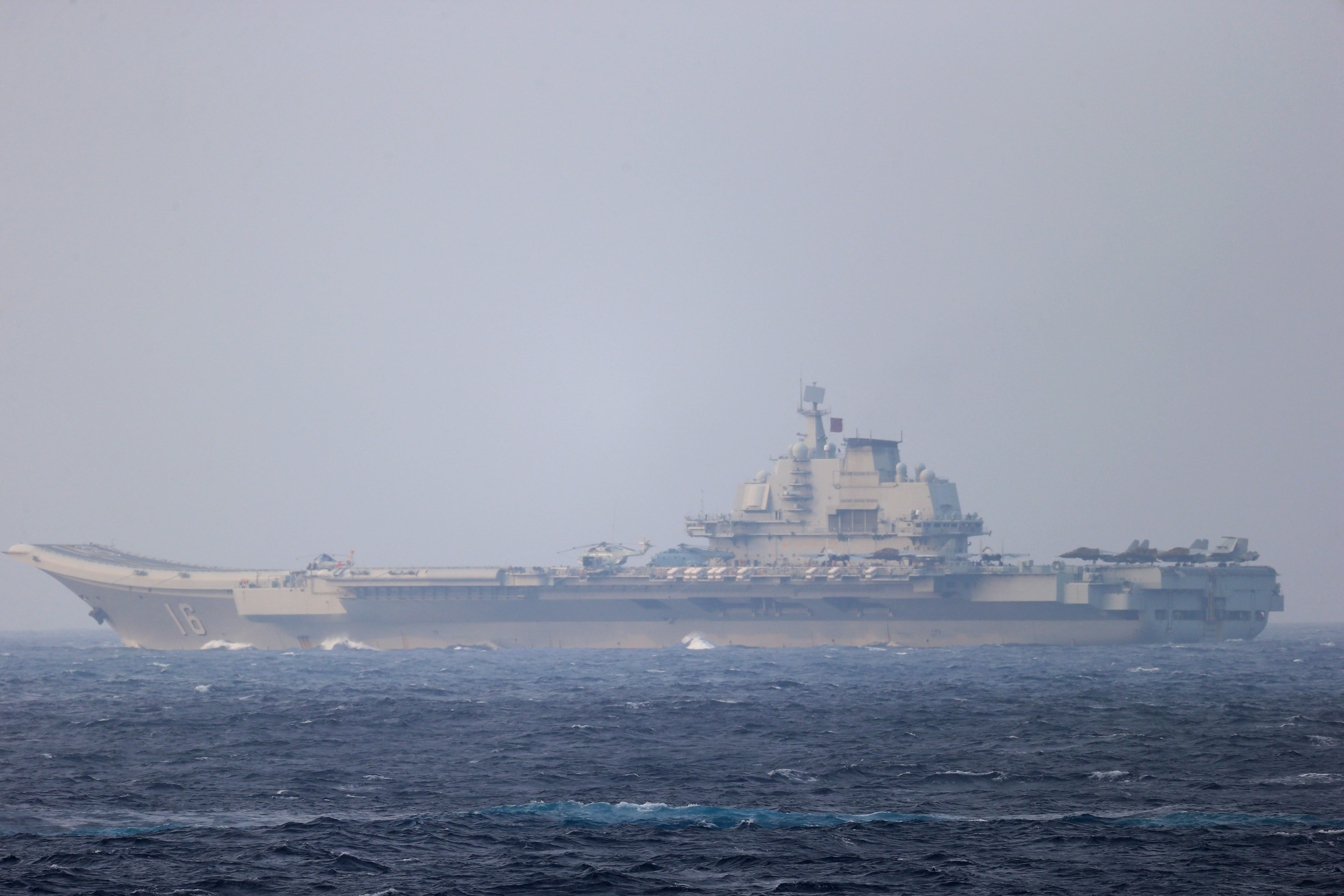 FILE PHOTO: Chinese aircraft carrier Liaoning sails through the Miyako Strait near Okinawa on its way to the Pacific in this handout photo taken by Japan Self- Defence Forces and released by the Joint Staff Office of the Defence Ministry of Japan on April 4, 2021. Joint Staff Office of the Defence Ministry of Japan/HANDOUT via REUTERS ATTENTION EDITORS - THIS IMAGE WAS PROVIDED BY A THIRD PARTY. MANDATORY CREDIT. THIS PICTURE WAS PROCESSED BY REUTERS TO ENHANCE QUALITY. AN UNPROCESSED VERSION HAS BEEN PROVIDED SEPARATELY/File Photo