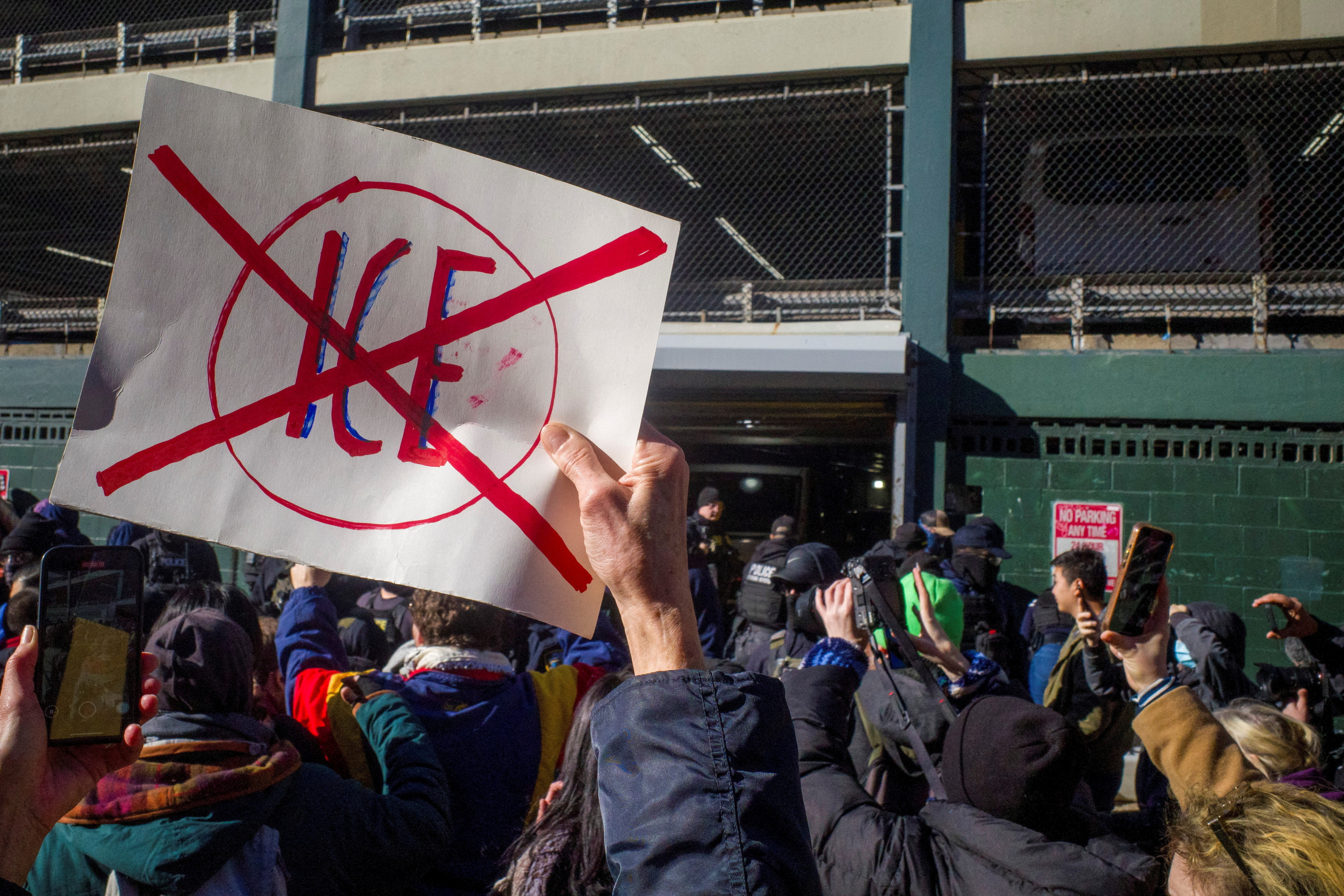 People hold banners as they gather in demonstration.