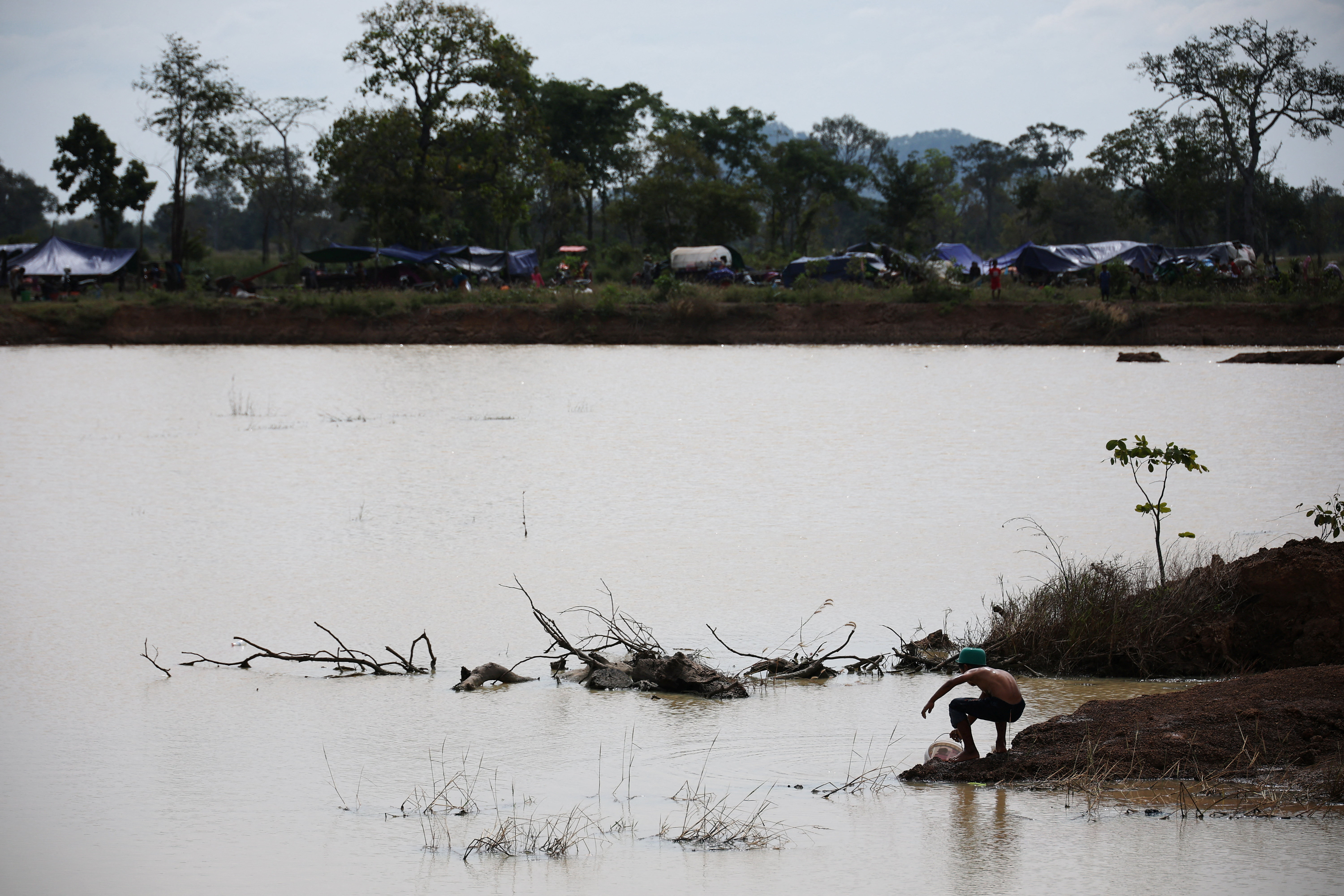 A boy collects water from reservoir at Chong Kal refugee camp after evacuation, amid deadly clashes between Thailand and Cambodia along a disputed border area, in Chong Kal, Oddar Meanchey Province, Cambodia, December 11, 2025. REUTERS/Kim Hong-Ji