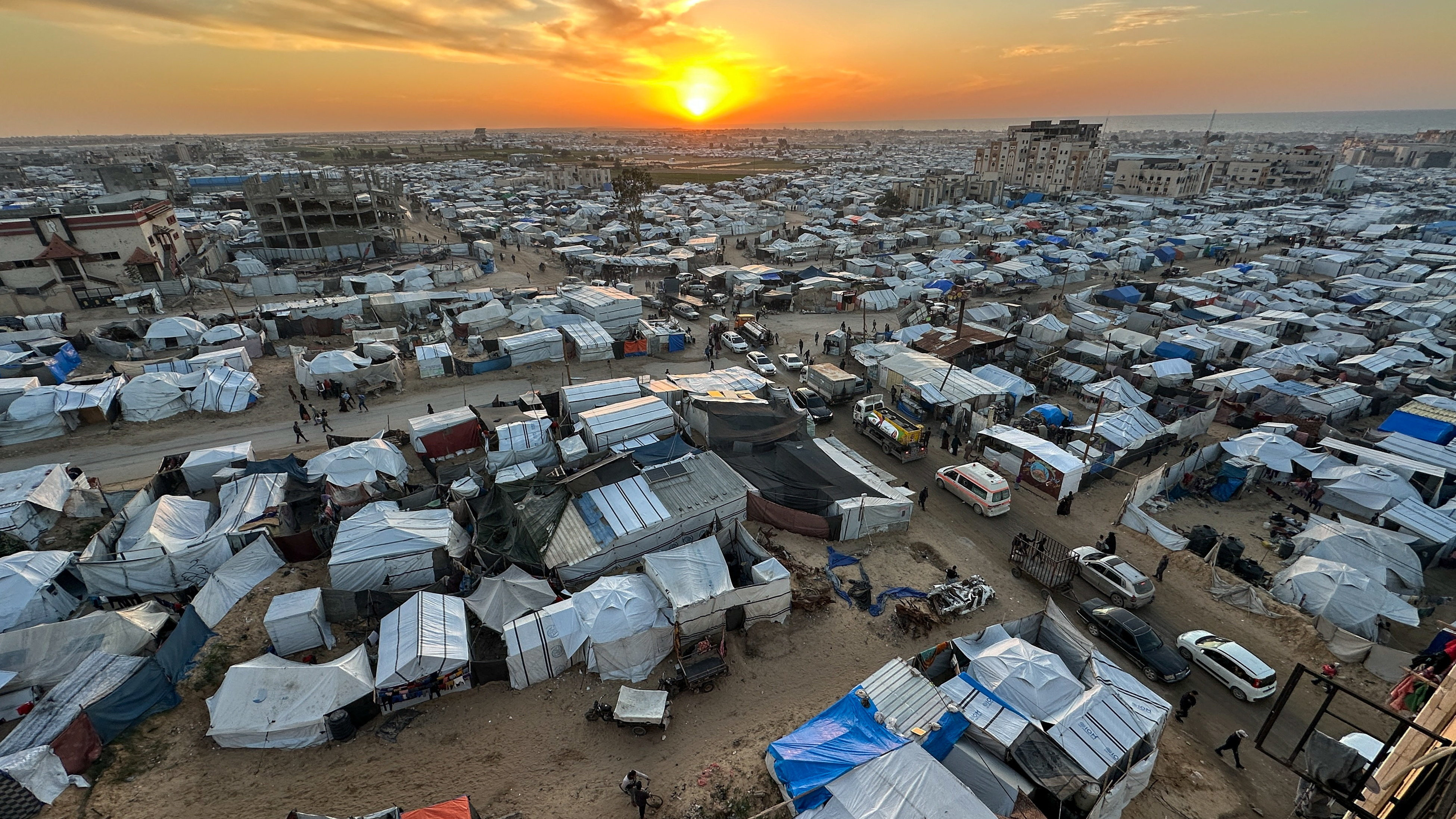 The sun sets over a tent camp sheltering Palestinians displaced by the Israeli offensive, on New Year’ Eve in Khan Younis, southern Gaza Strip, December 31, 2025. [Ramadan Abed/Reuters]