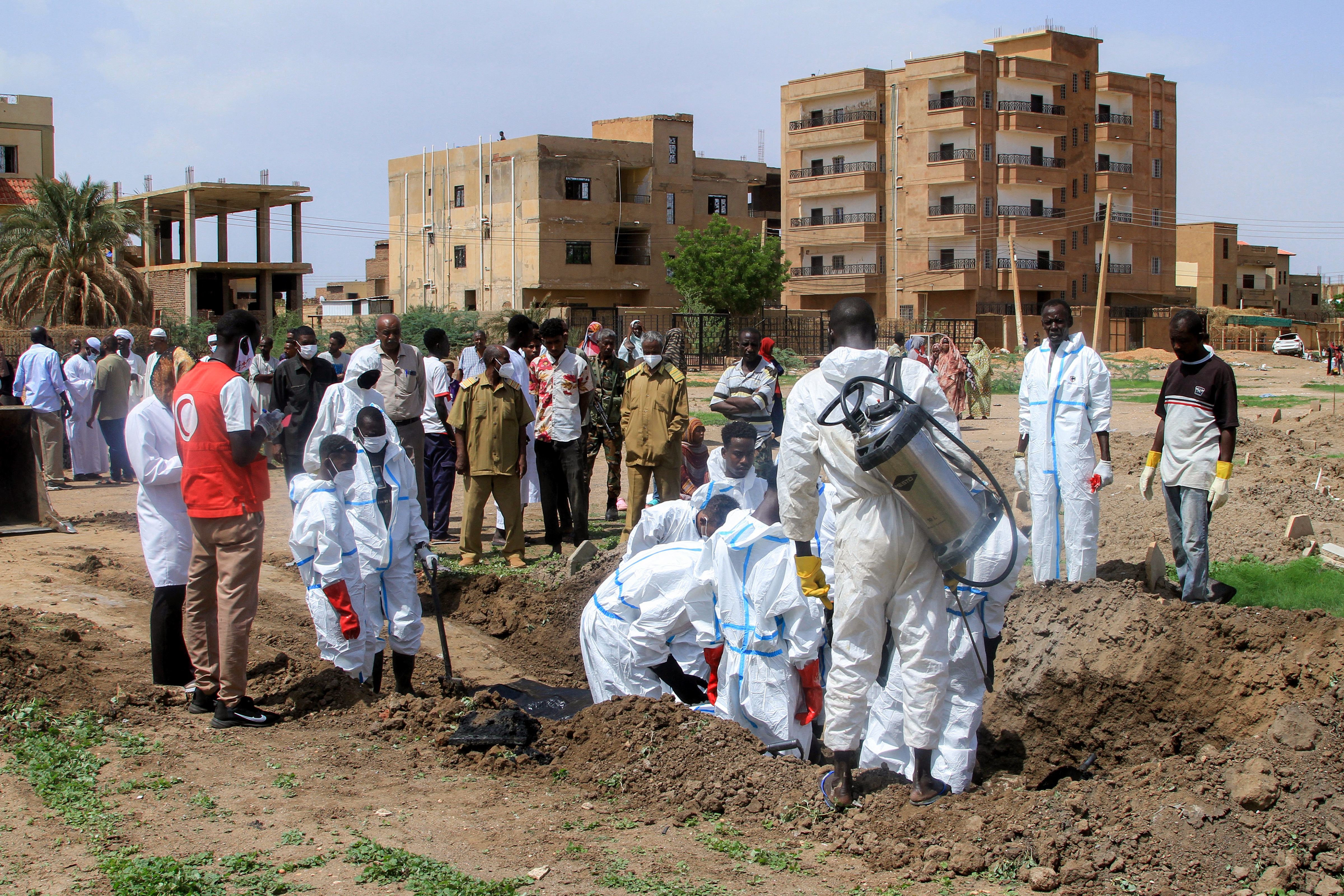 Members of the Sudanese Red Crescent and forensic experts exhume the remains of people from makeshift graves for reburial in the local cemetery in Khartoum's southern suburb of al-Azhari on August 2, 2025 after the dead were buried in a rush when the area was under control of the Rapid Support Forces (RSF) paramilitaries. In Sudan's war-scarred capital Khartoum, Red Crescent volunteers have begun the grisly task of exhuming the dead from makeshift plots where they were buried during the fighting so their families can give them a proper funeral. (Photo by Ebrahim Hamid / AFP)
