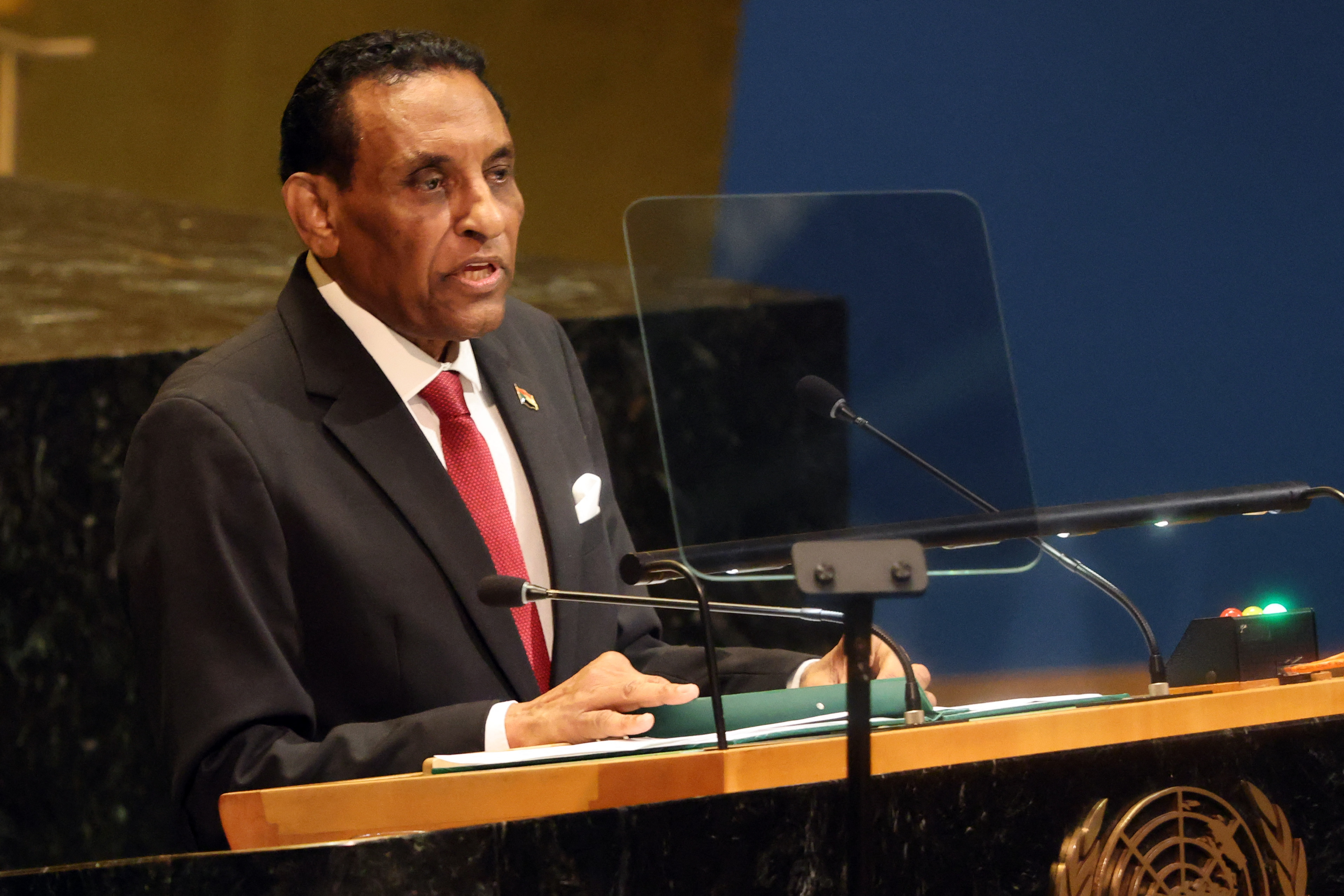 Sudanese Prime Minister Kamil Idris speaks at a podium.