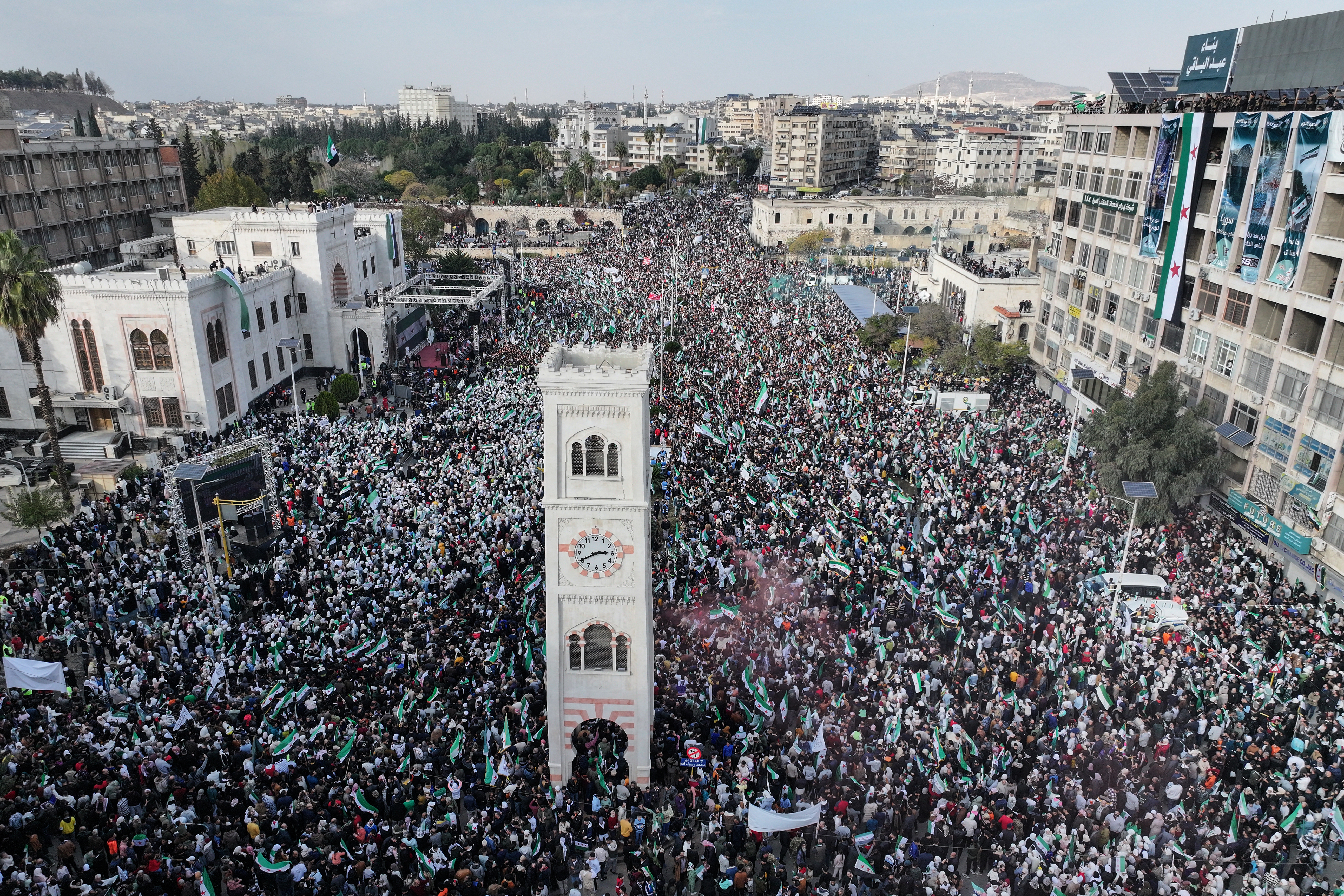 Residents gather with Syrian flags during celebrations marking one year