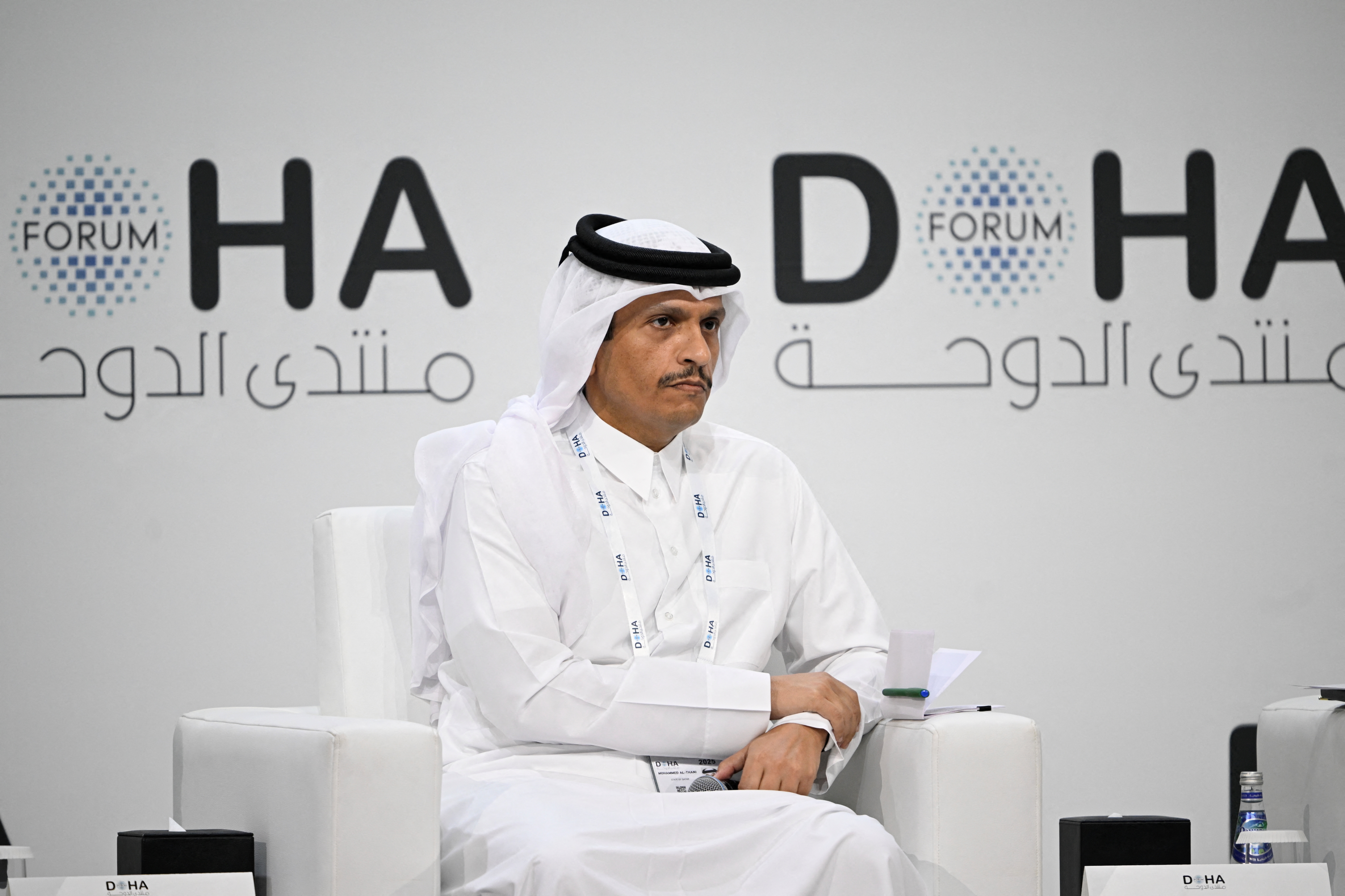 Qatar's Prime Minister and Minister for Foreign Affairs Sheikh Mohammed bin Abdulrahman bin Jassim Al Thani seated with the logo of the Doha Forum behind him.