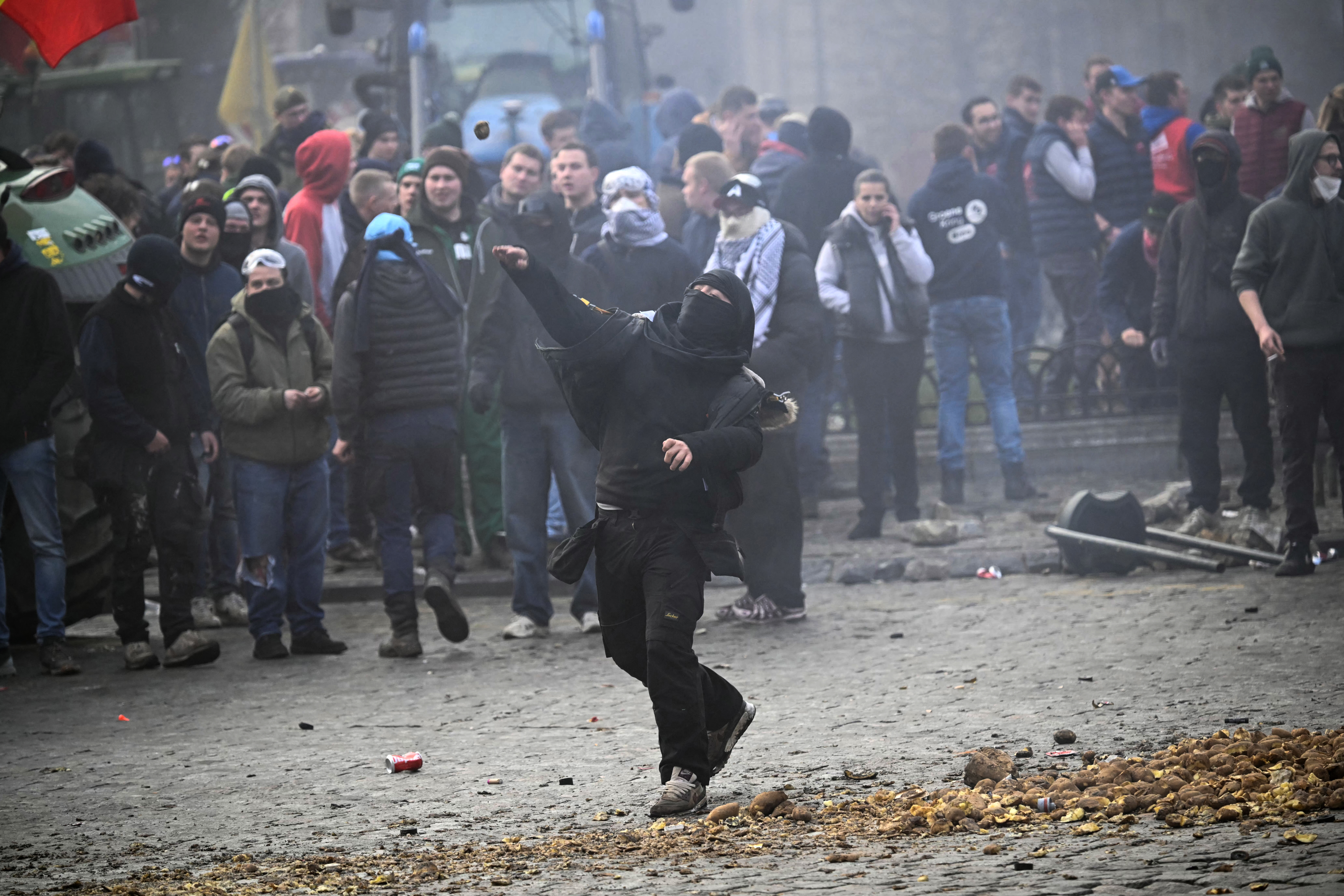 A farmer throws a potato near the European Parliament at the Place du Luxembourg