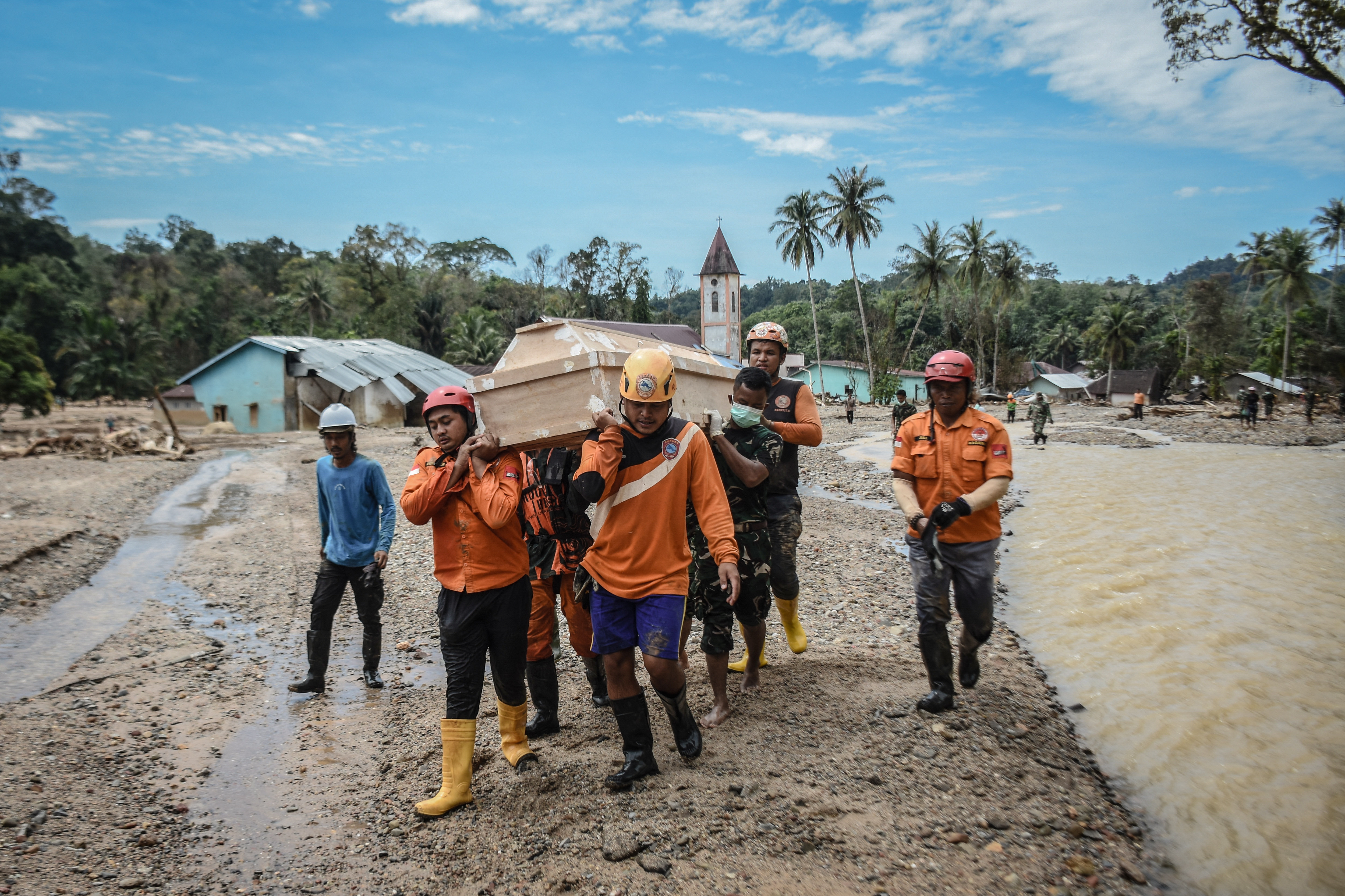Search and rescue teams transport a coffin, relocating graves of flash flood victims in Hutanabolon, North Sumatra, amid concerns that heavy rainfall could wash away the burial sites again. According to government data released December 16, the catastrophic flooding has claimed 1,030 lives, with 205 people still unaccounted for. This disaster ranks among the deadliest natural calamities to strike Aceh province in Sumatra - a resource-rich region that also suffered from the devastating 2004 tsunami. [Damai Mendrofa / AFP]