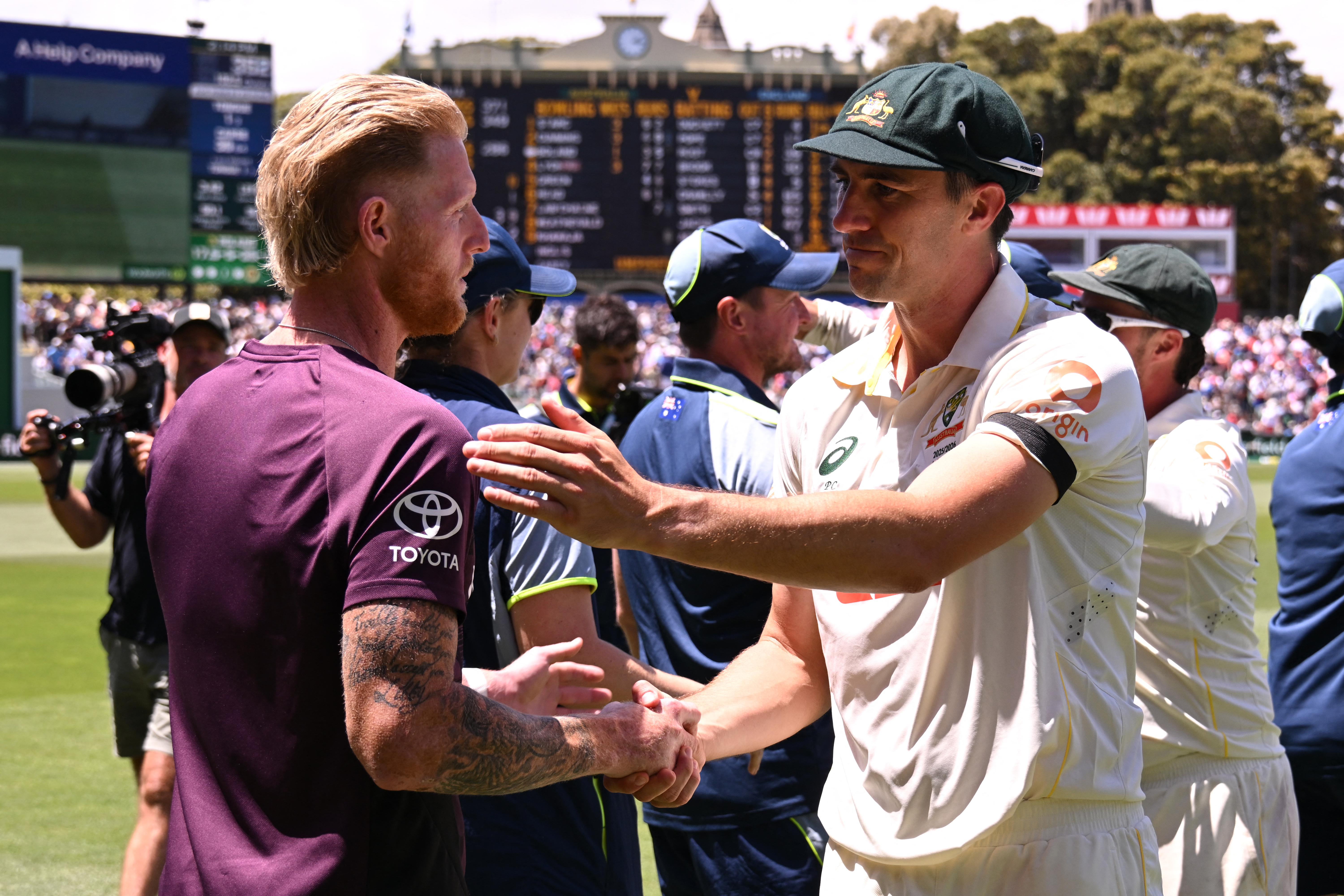 Ben Stokes and Pat Cummins react.
