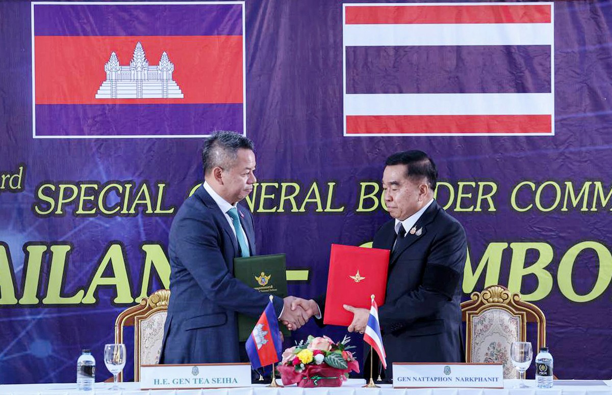 This handout photo released by Agence Kampuchea Press (AKP) on December 27, 2025 shows Cambodia's defence minister Tea Seiha (L) and Thailand's defence minister Nattaphon Narkphanit (R) shaking hands and exchanging documents during the special General Border Committee (GBC) meeting at a border checkpoint in Thailand's Chanthaburi province. Thailand and Cambodia agreed to an "immediate" ceasefire on December 27, 2025, the two countries said in a joint statement, pledging to end weeks of deadly border clashes. (Photo by Handout / Agence Kampuchea Press (AKP) / AFP) / RESTRICTED TO EDITORIAL USE - MANDATORY CREDIT "AFP PHOTO / AGENCE KAMPUCHEA PRESS (AKP)" - HANDOUT - NO MARKETING NO ADVERTISING CAMPAIGNS - DISTRIBUTED AS A SERVICE TO CLIENTS