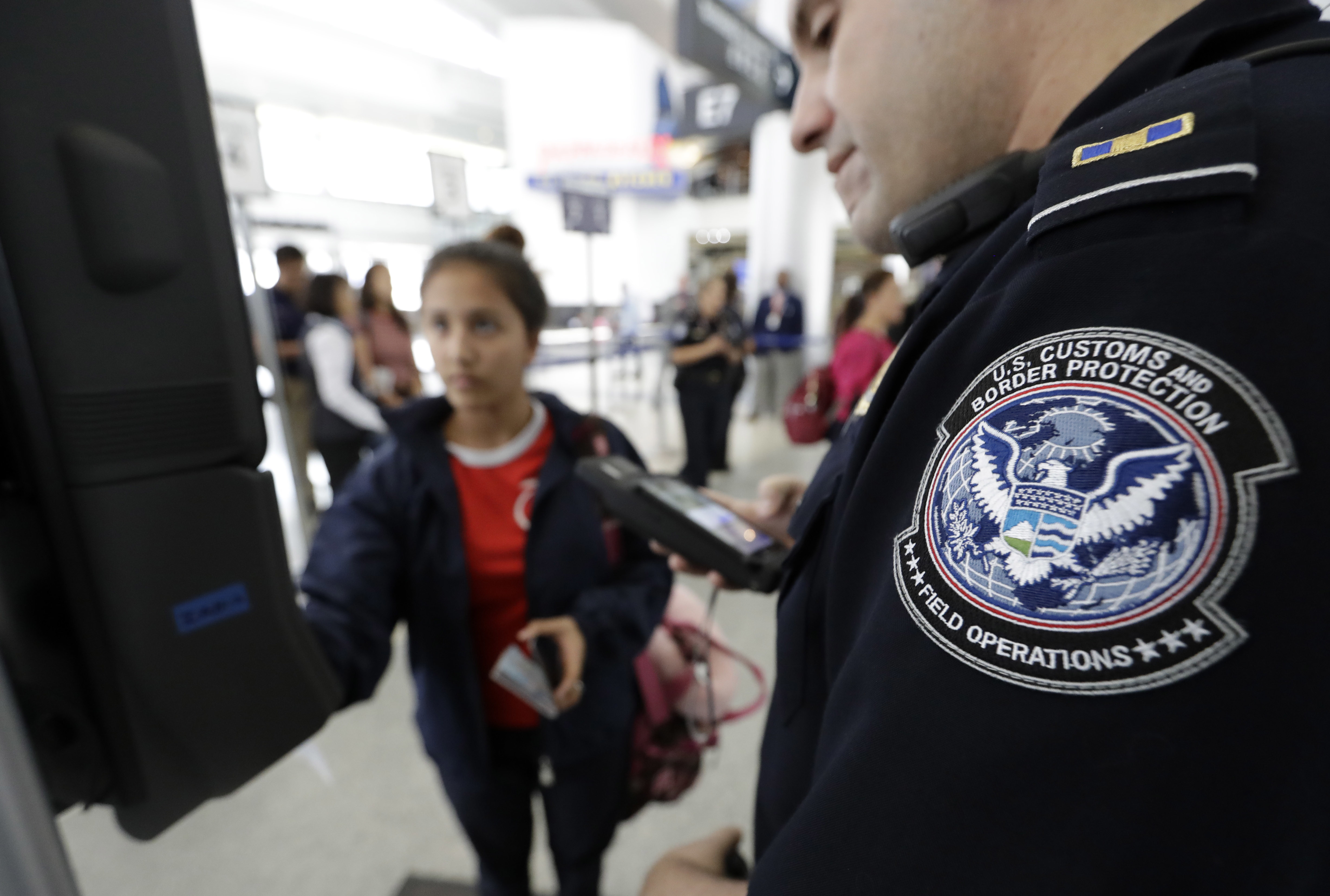 U.S. Customs and Border Protection officer Julio Corro, right, helps a passenger navigate one of the new facial recognition kiosks at a United Airlines gate before boarding a flight to Tokyo, Wednesday, July 12, 2017, at George Bush Intercontinental Airport, in Houston. The Trump administration intends to require that American citizens boarding international flights submit to face scans, something Congress has not explicitly approved and privacy advocates consider an ill-advised step toward a surveillance state. (AP Photo/David J. Phillip)