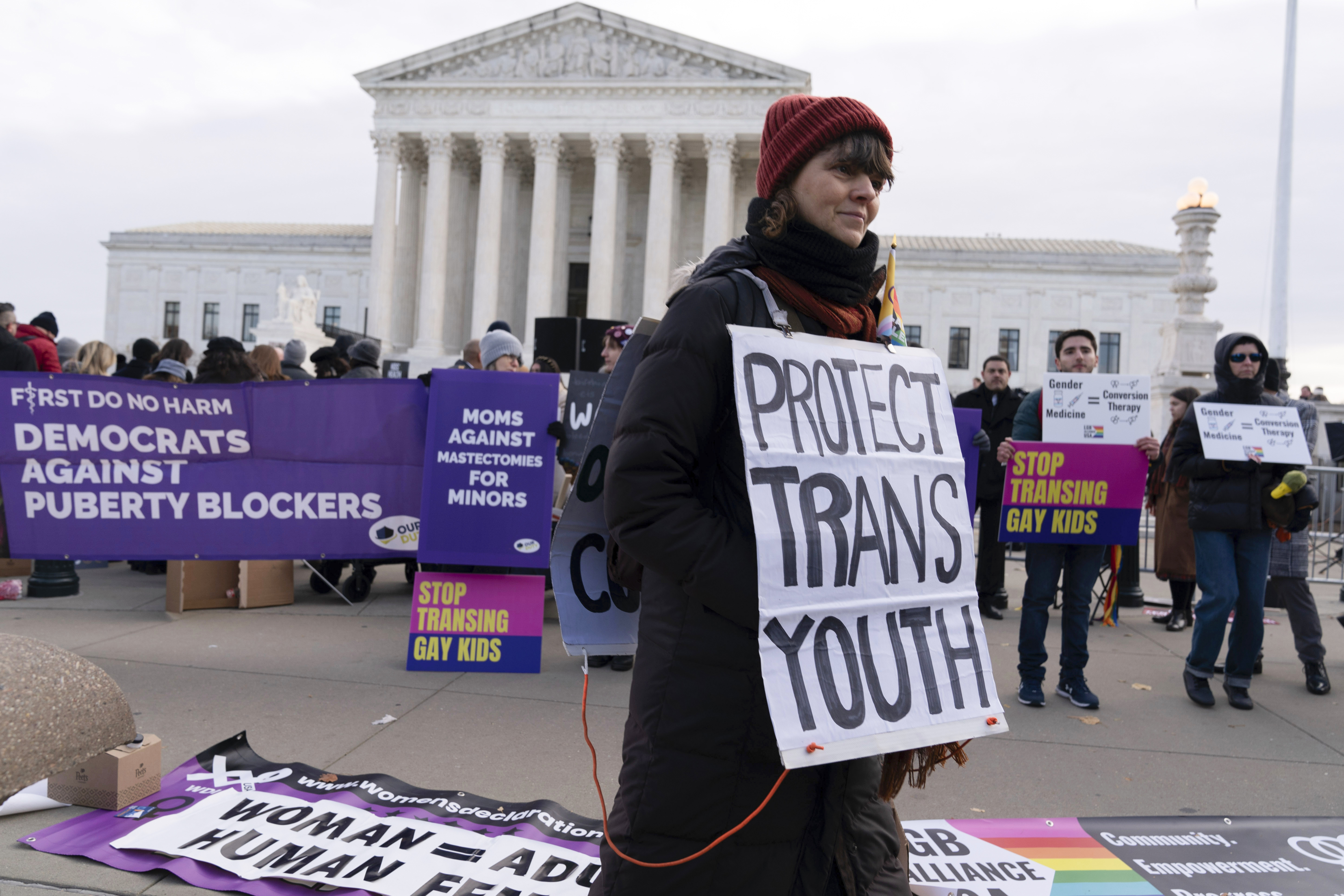 A protester holds up a sign that reads "Protect Trans Youth"