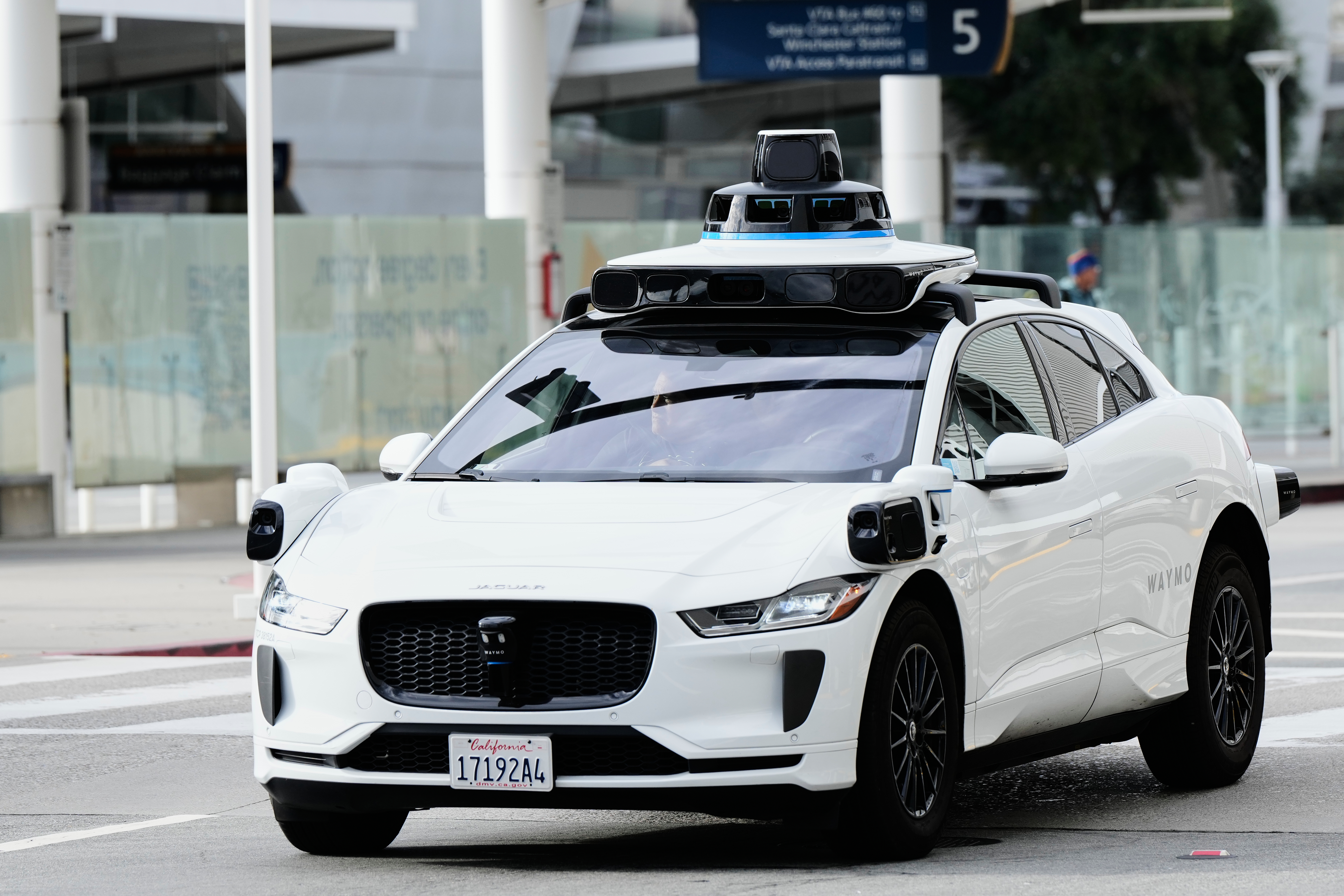 A passenger inside a Waymo vehicle looks out of the window while leaving the San Jose Mineta International Airport in US