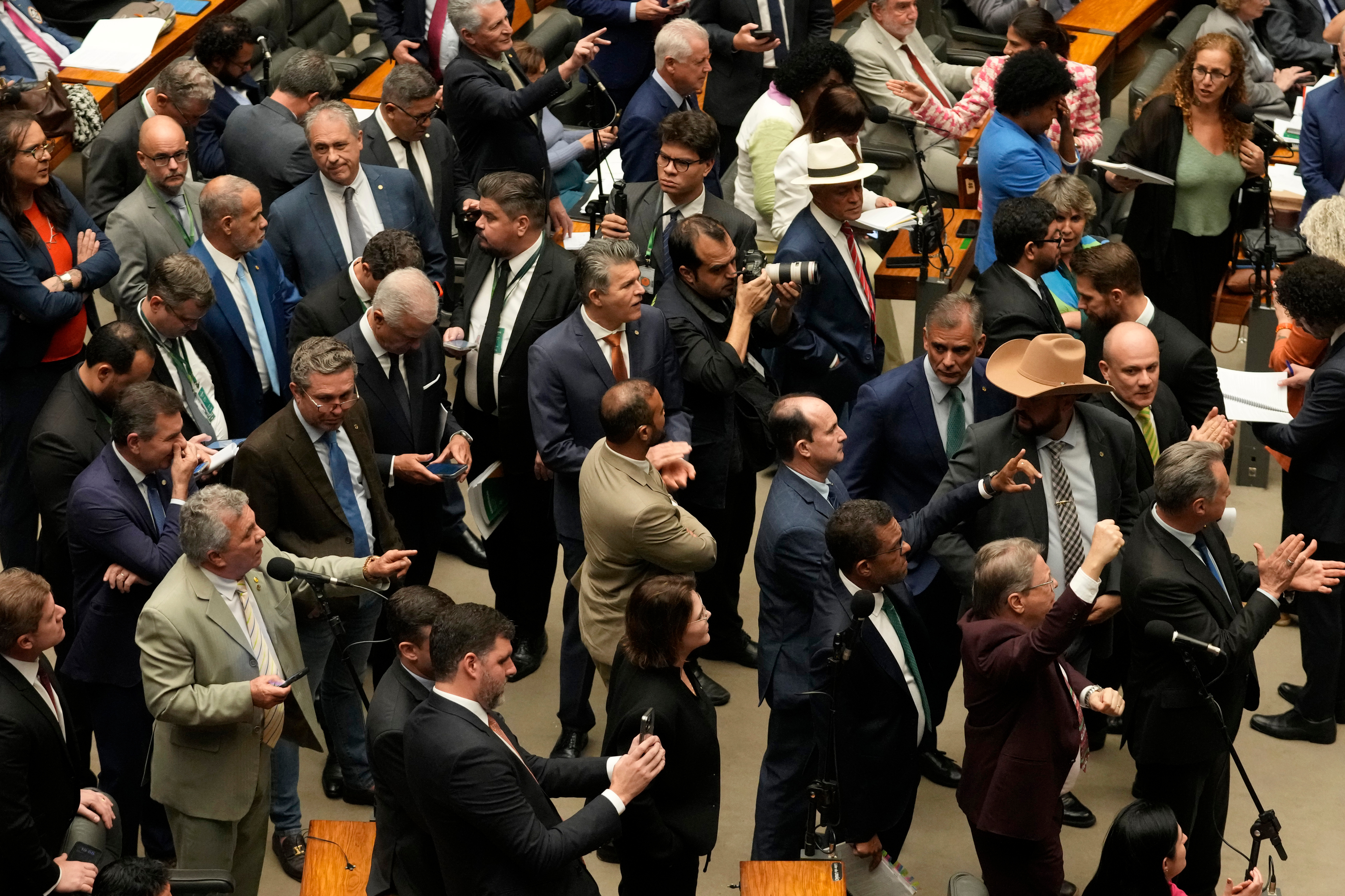 Members of Brazil's Chamber of Deputies standing up on the chamber floor.