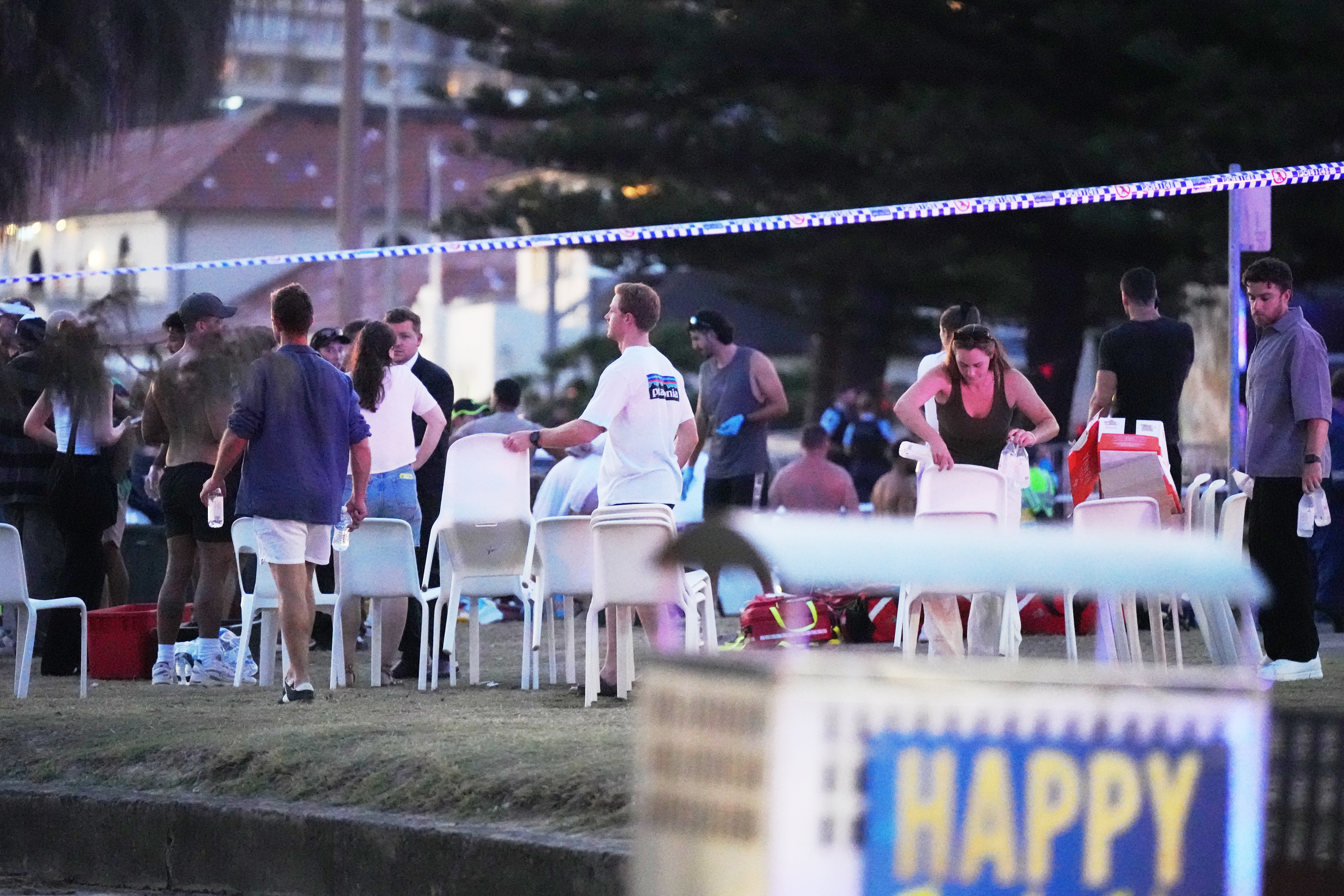 People and emergency workers gather at location where a holiday event was taking place and then a reported shooting at Bondi Beach in Sydney