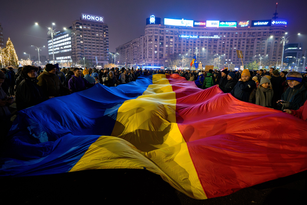 People wave a Romanian flag during a protest.