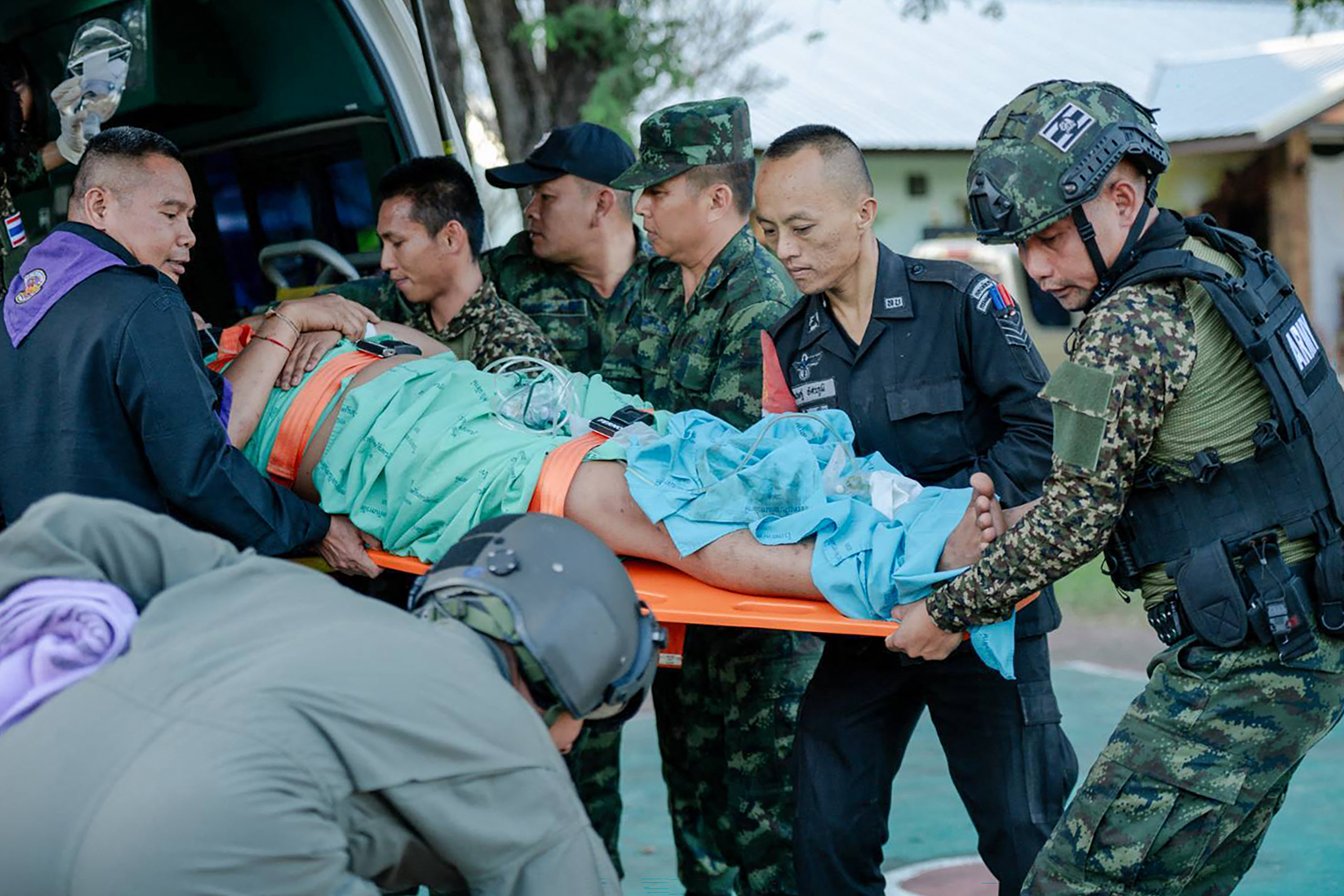 An injured Thai soldier being evacuated by others into an ambulance.