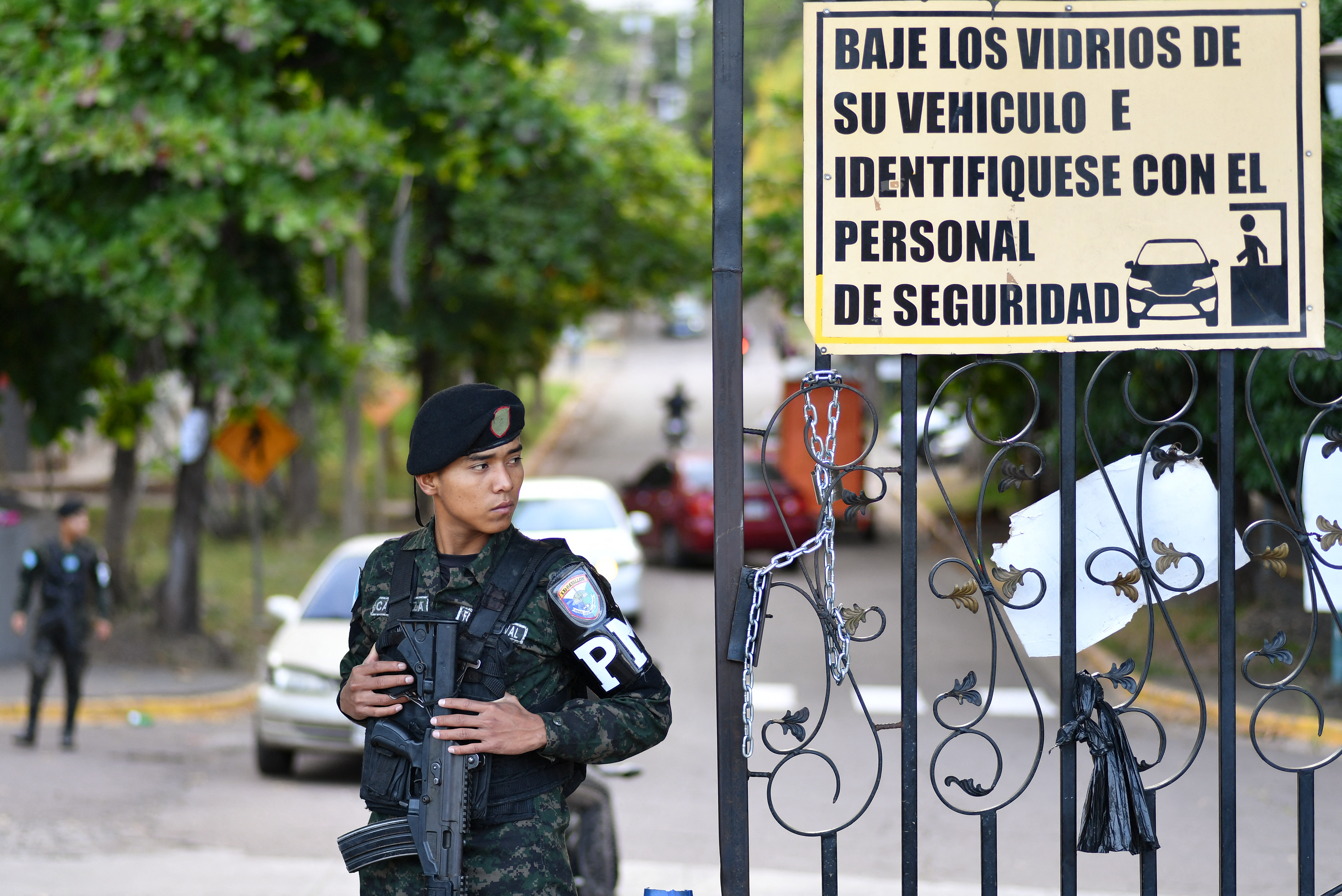A member of the Military Police stand guard at the entrance of the Professional Formation National Institute (INFOP) headquarters, where the electoral material of the last presidential election is being counted, in Tegucigalpa on December 13, 2025.