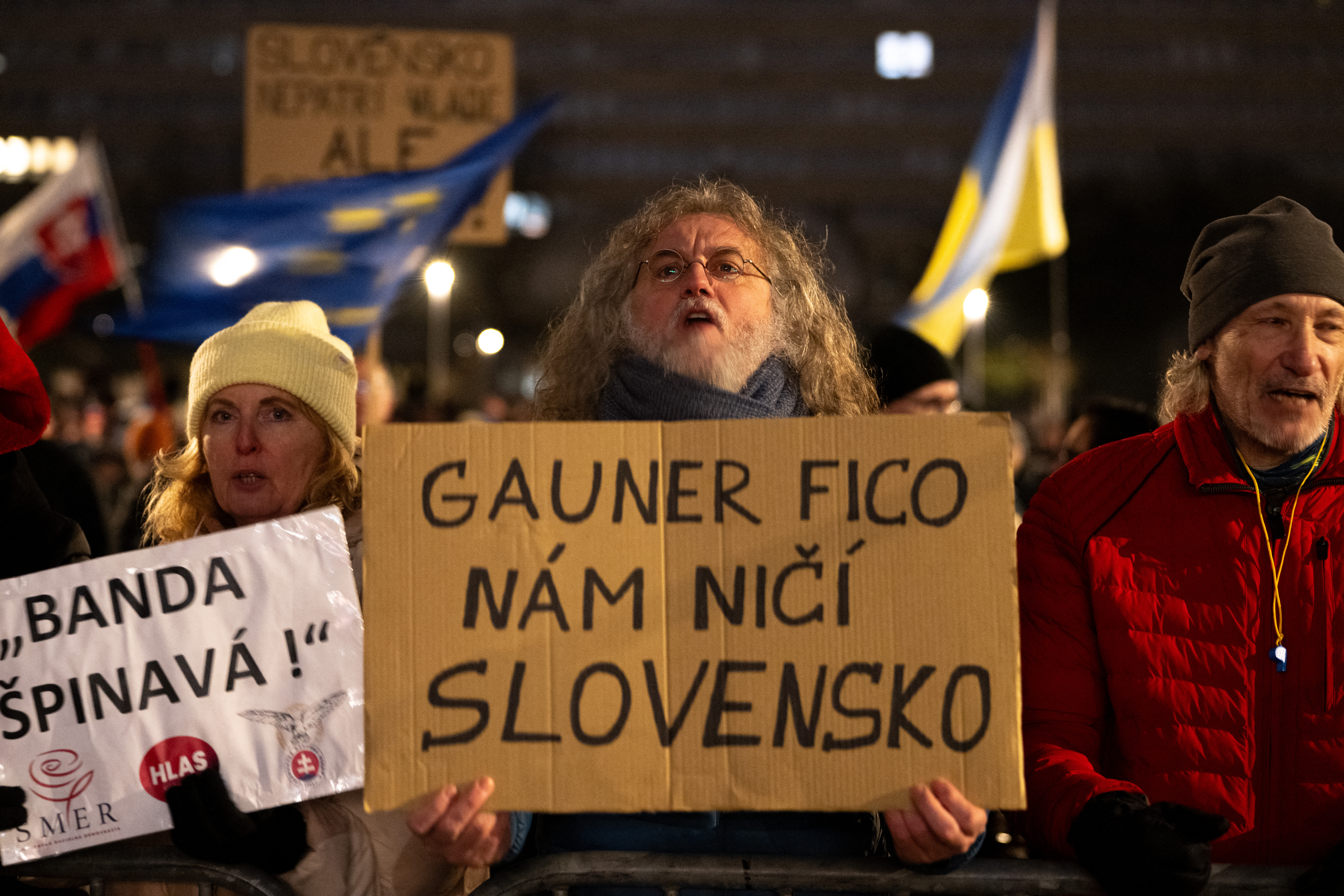 A man holds a banner reading "Gangster Fico is destroying Slovakia" during a protest against the abolition of the whistleblower protection office and penal code changes in Bratislava, Slovakia on December 15, 2025.