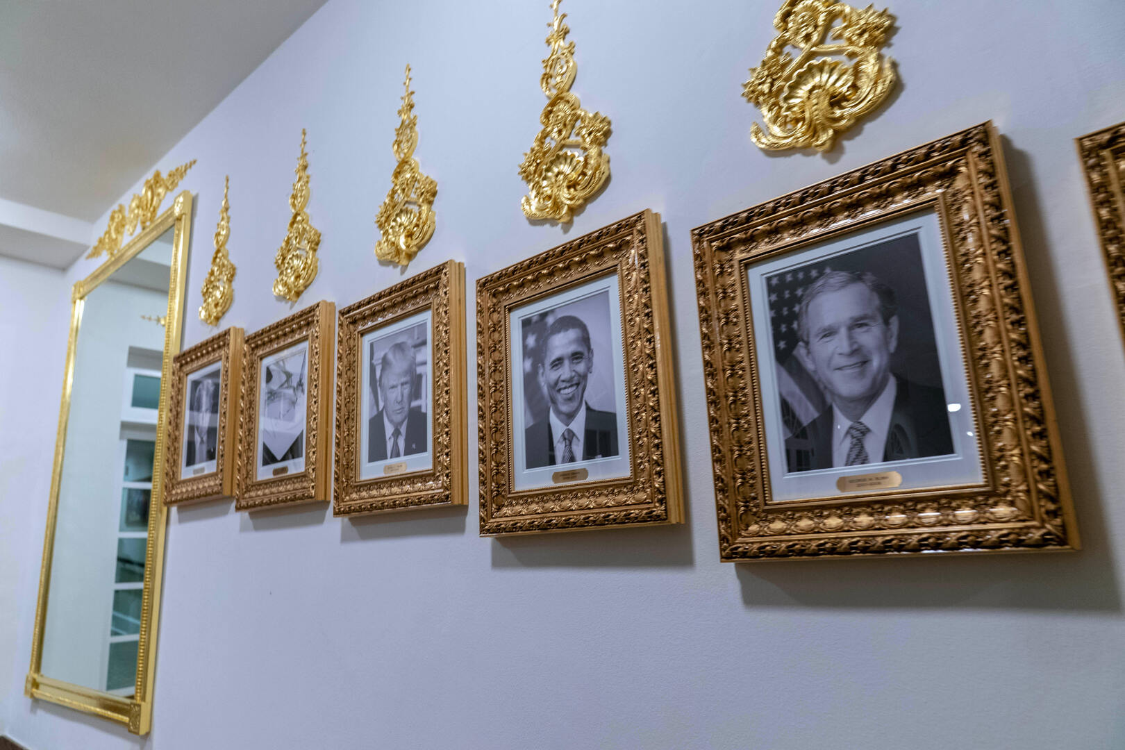 A mirror with framed images of President Donald Trump, former President Joe Biden's autopen signature, second from left, former President Barack Obama, and former President George W. Bush appear on the Presidential Walk of Fame on the colonnade of the White House on Oct. 19, 2025, in Washington, DC, US. [Jose Luis Magana/AP]