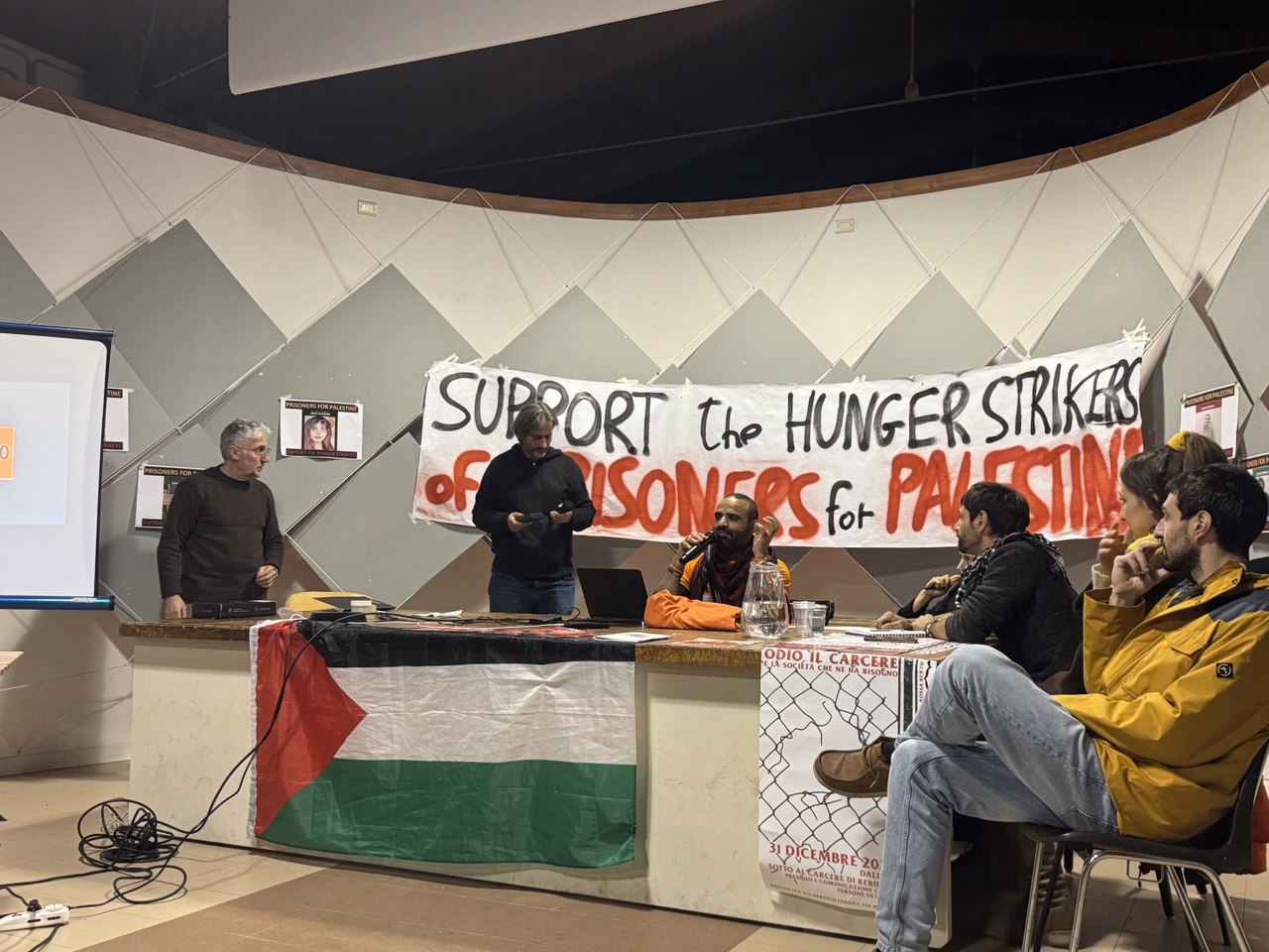 A table with speakers at an event in support of Pal Action hunger strikers