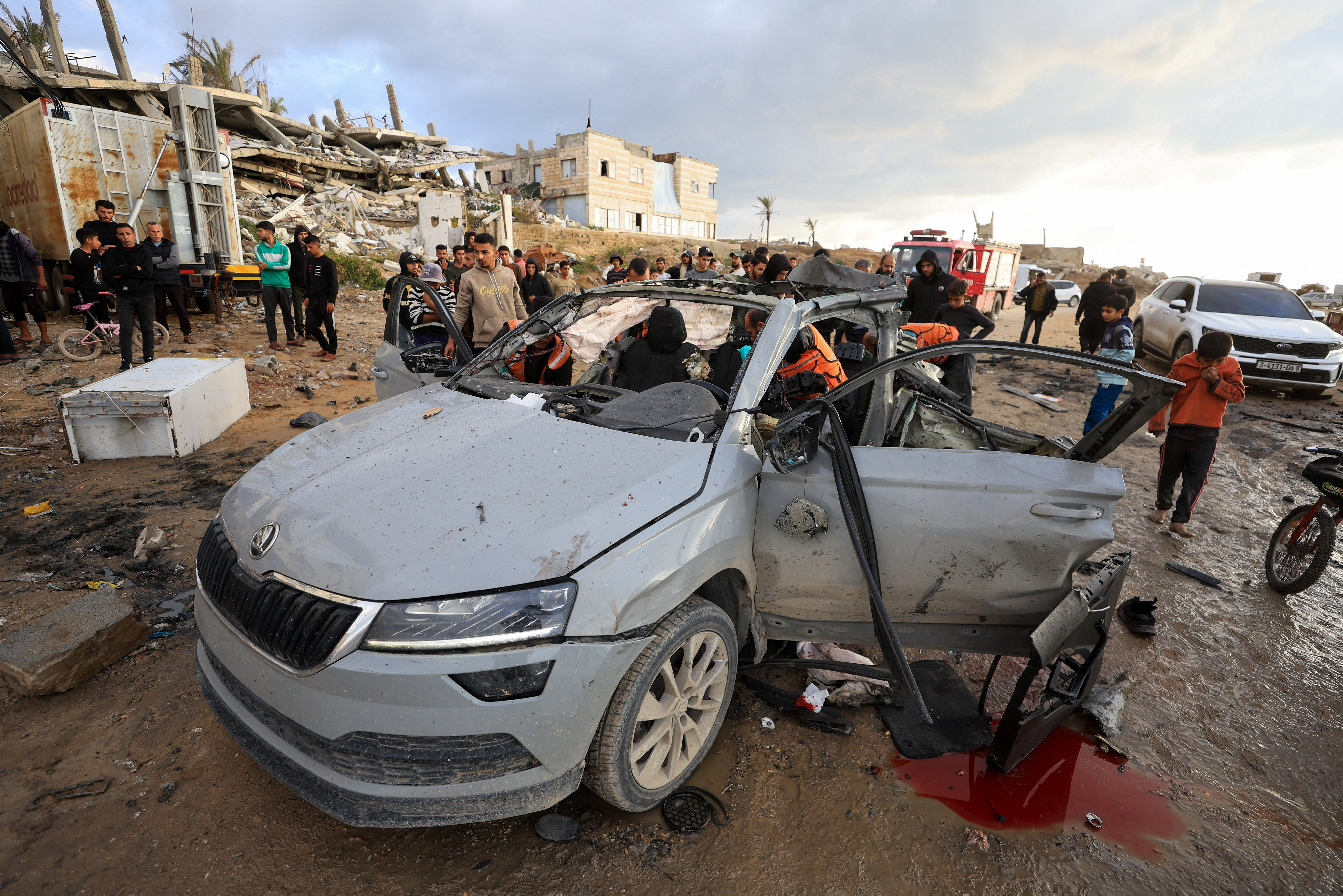 Palestinians inspect the site of an Israeli strike on a car in Gaza City, December 13, 2025.REUTERS/Dawoud Abu Alkas