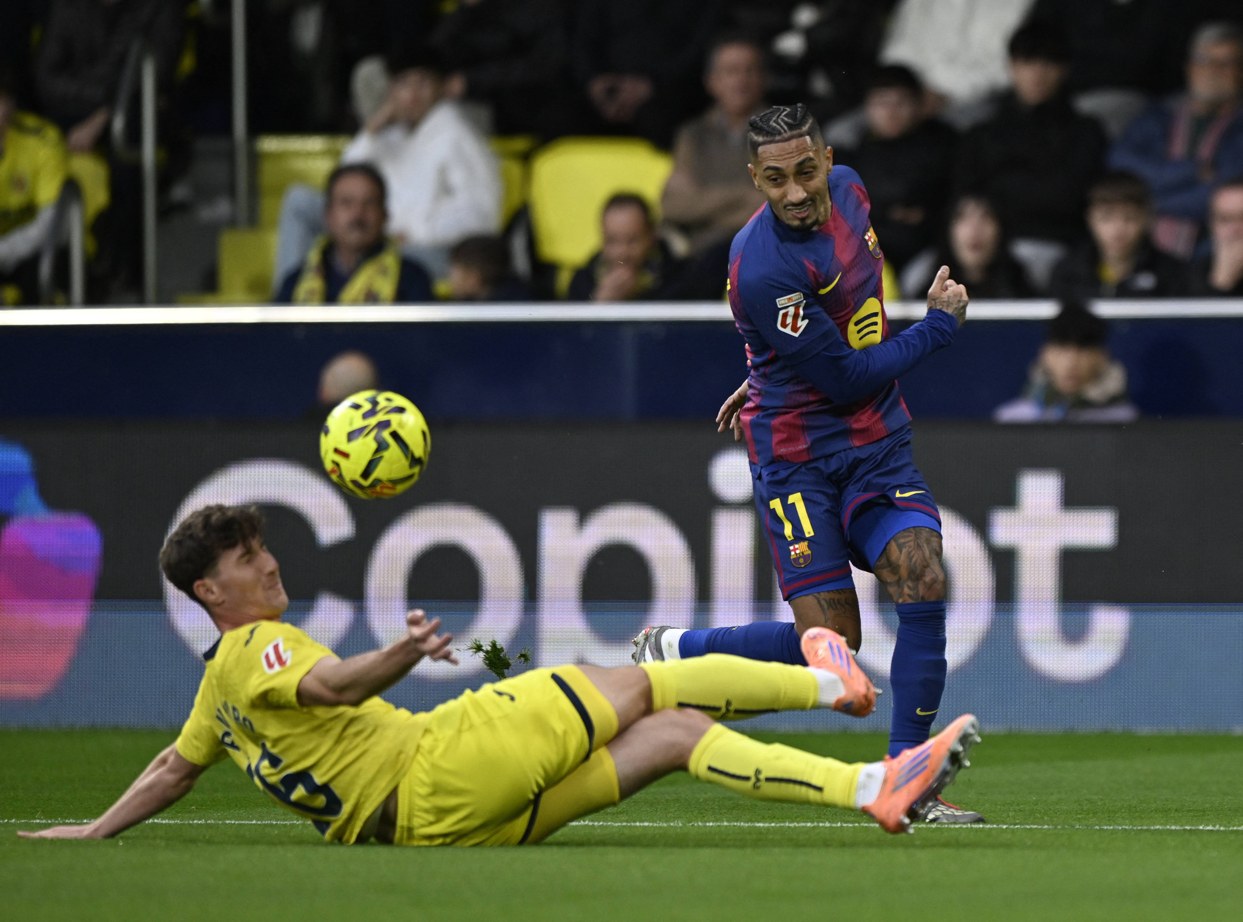 Soccer Football - LaLiga - Villarreal v FC Barcelona - Estadio de la Ceramica, Villarreal, Spain - December 21, 2025 FC Barcelona's Raphinha in action with Villarreal's Pau Navarro REUTERS/Pablo Morano