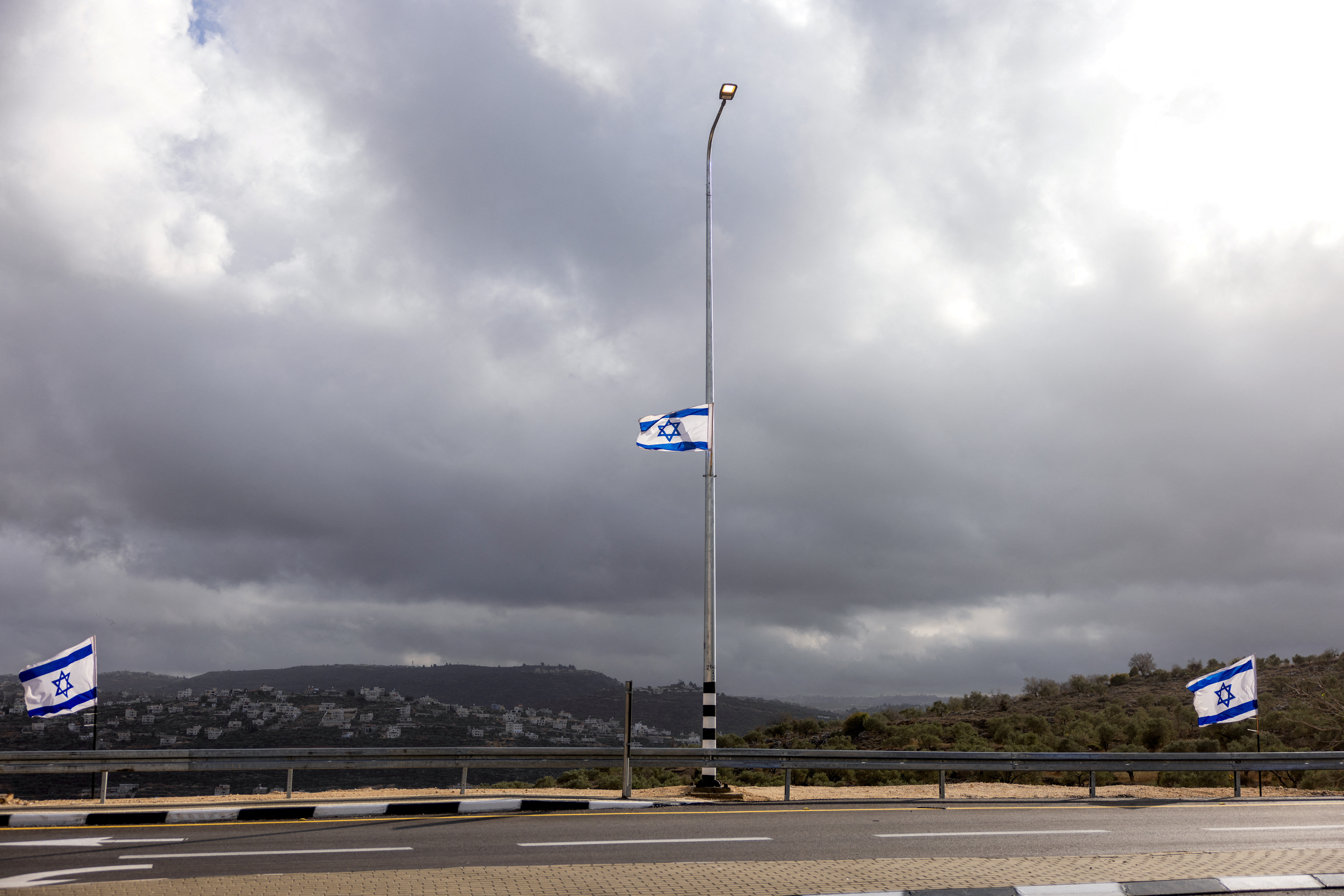 Israeli flags flutter at the entrance to Evyatar, an Israeli settlement in the Israeli-occupied West Bank, November 30, 2025. REUTERS/Ronen Zvulun