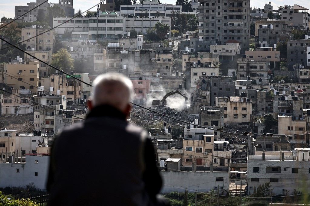 Residents of the Nur Shams Palestinian refugee camp watch their homes being demolished on New Year's eve by an Israeli military excavator in the Nur Shams camp, on December 31, 2025. Zain Jaafar/AFP]