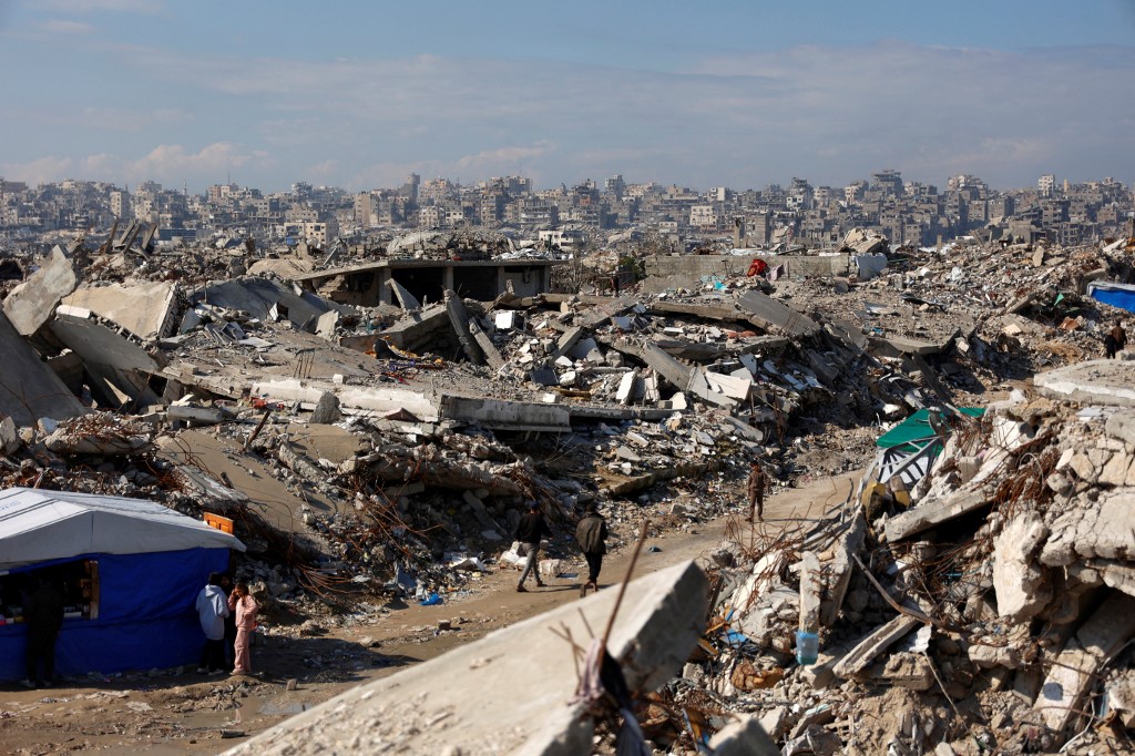 Displaced Palestinians live amongst the rubble and debris of homes and businesses destroyed by the Israeli military in over two years of military strikes on the Gaza Strip enclave, in Jabalia refugee camp, in the northern Gaza Strip on January 17, 2026. US President Donald Trump's so-called "Board of Peace" for postwar Gaza began to take shape on January 17, with the leaders of Egypt, Turkey, Argentina and Canada asked to join. (Photo by Omar AL-QATTAA / AFP)
