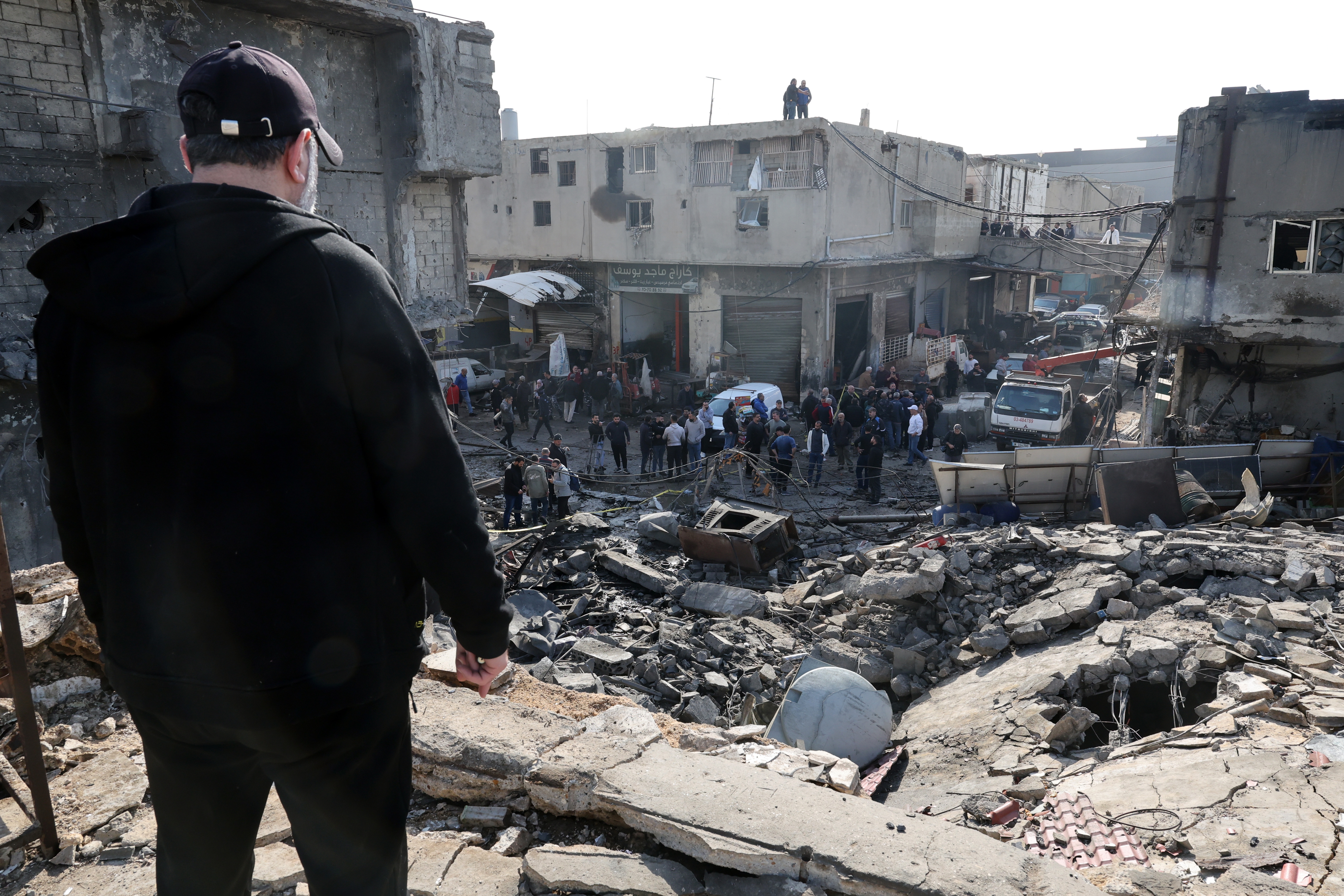 People inspect a destroyed building following an Israeli air strike in an industrial area of Ghaziyeh, Sidon District, southern Lebanon