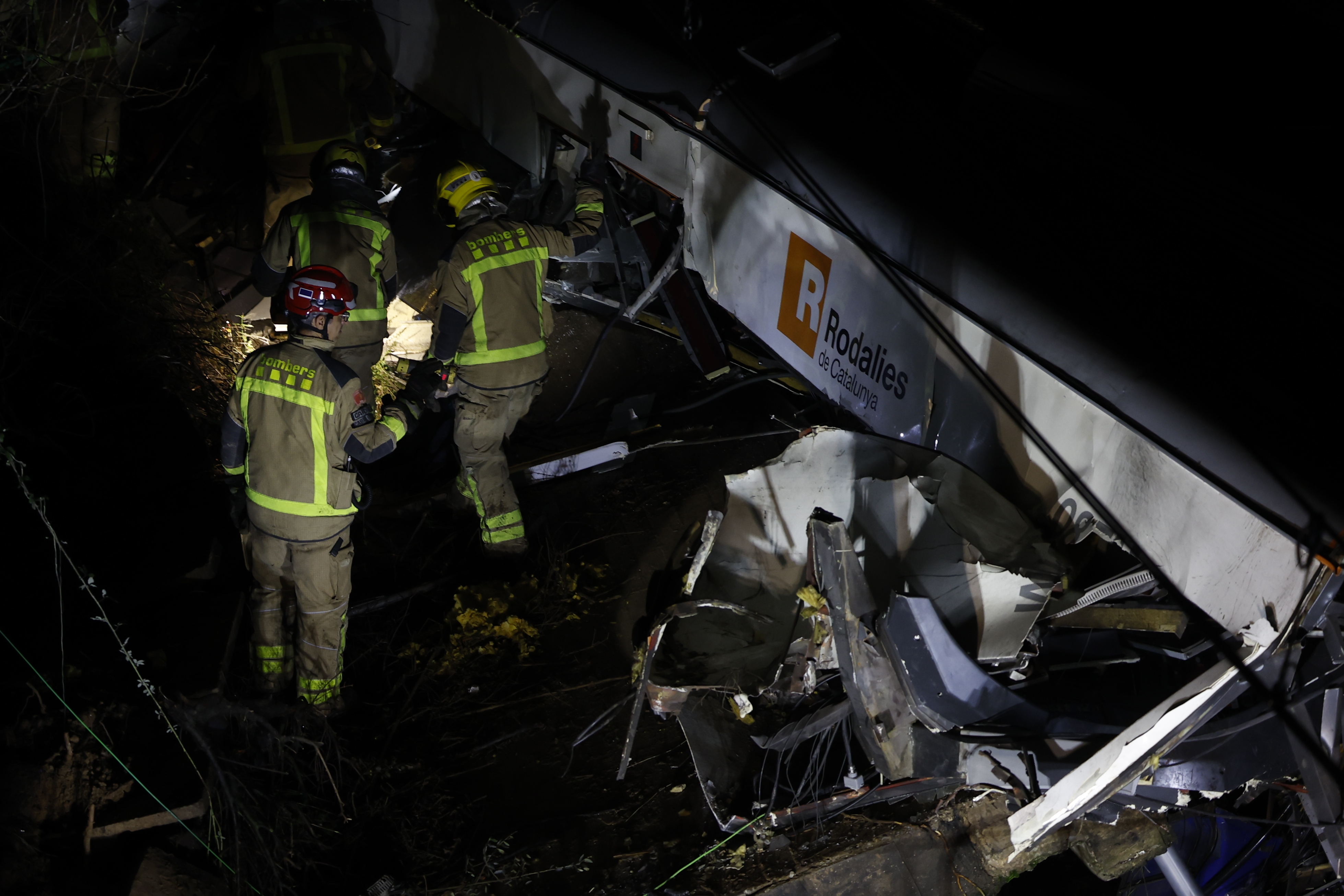 epa12666051 Generalitat's firemen work at the place where a train crashed with a collapsed wall which fell to the via at Gelida city in Barcelona, Spain, 20 January 2026. The train machinist died and fifteen people were injured. EPA/Alberto Estevez