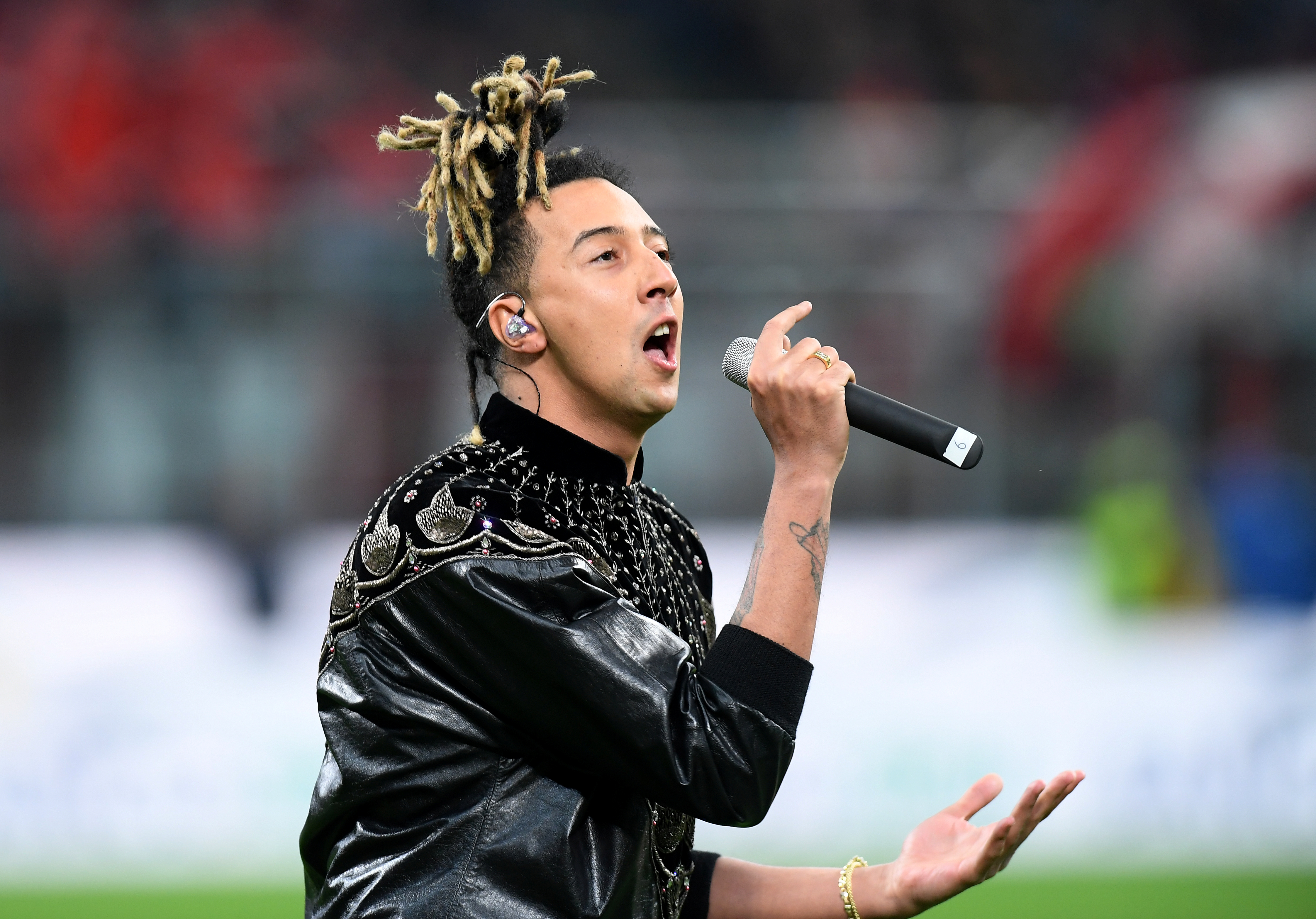 Musician Ghali performs on the pitch before a football match.