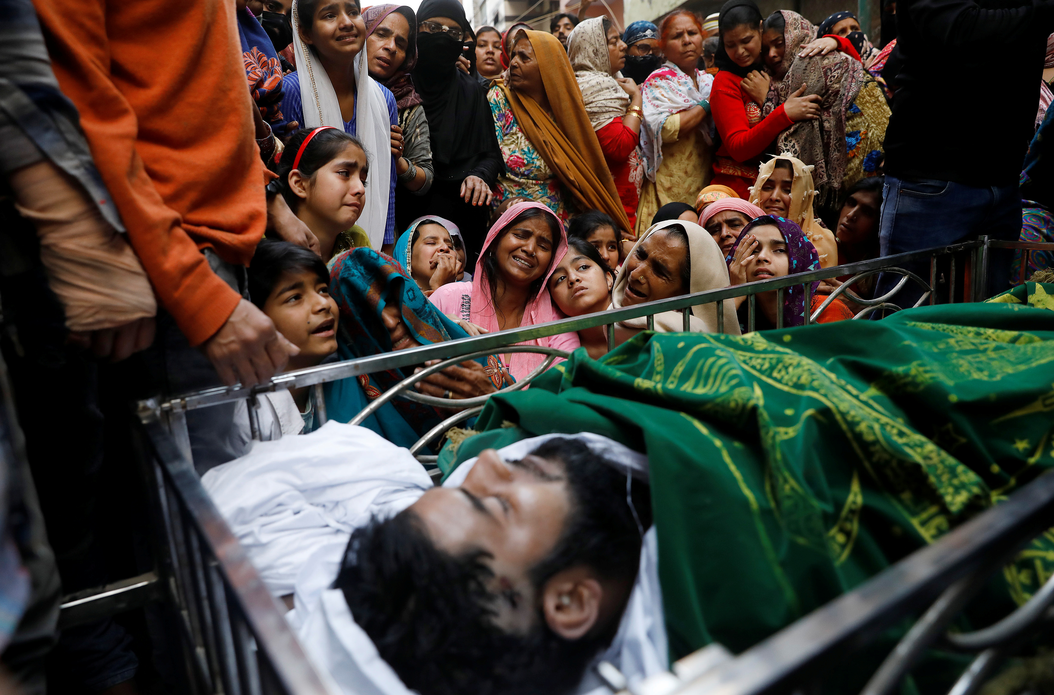 Relatives mourn next to the body of Muddasir Khan, who was wounded in a clash between people demonstrating for and against a new citizenship law, after he succumbed to his injuries, in a riot-affected area of New Delhi, India, February 27, 2020