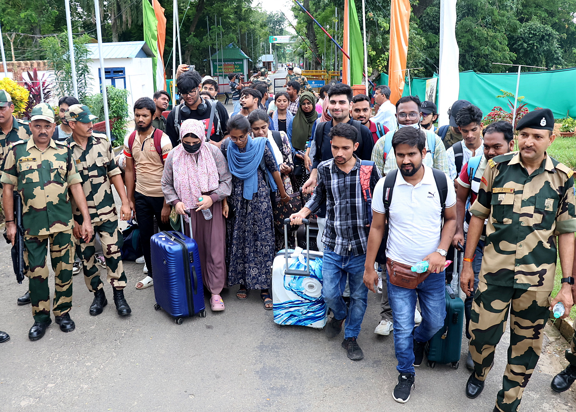 Members of India's Border Security Force (BSF) escort Indian students, who study in Bangladesh, after they crossed over at the Akhaura check post of the India-Bangladesh border in the northeastern Indian state of Tripura, following protests against government job quotas in Bangladesh, July 20, 2024. REUTERS/Jayanta Dey